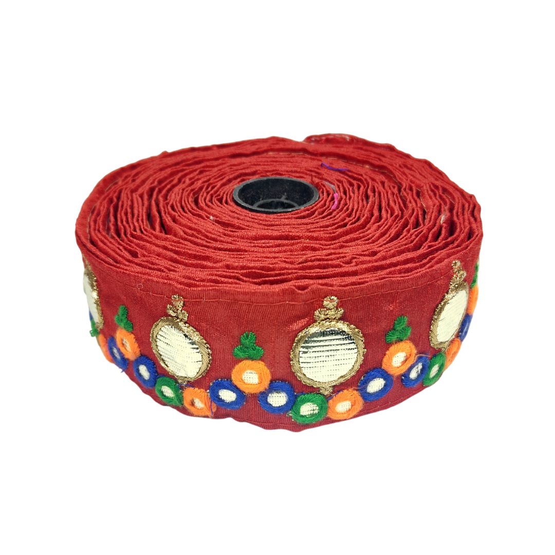 Roll of red fabric with decorative patterns on a white background