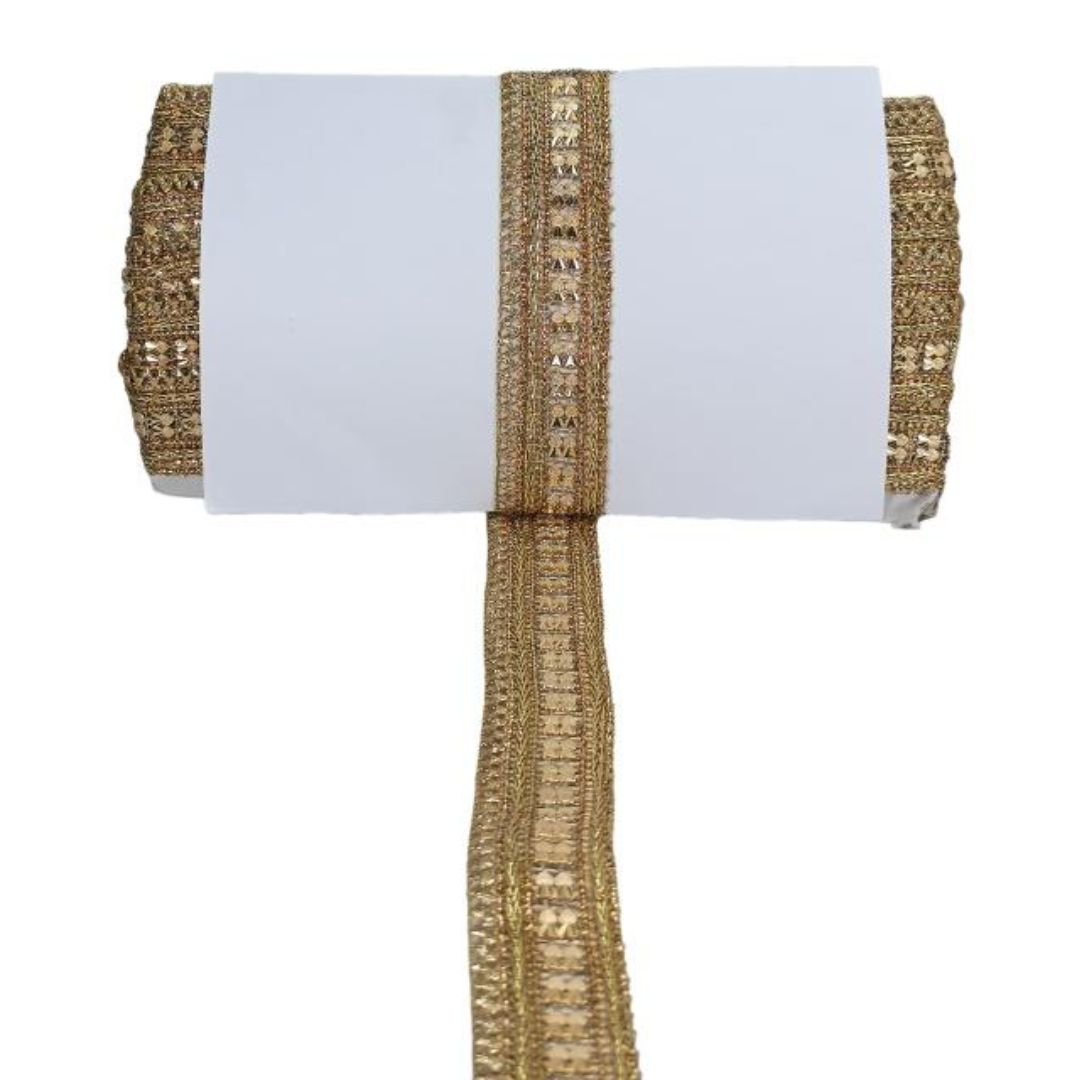 Roll of gold ribbon with decorative stones on a white background