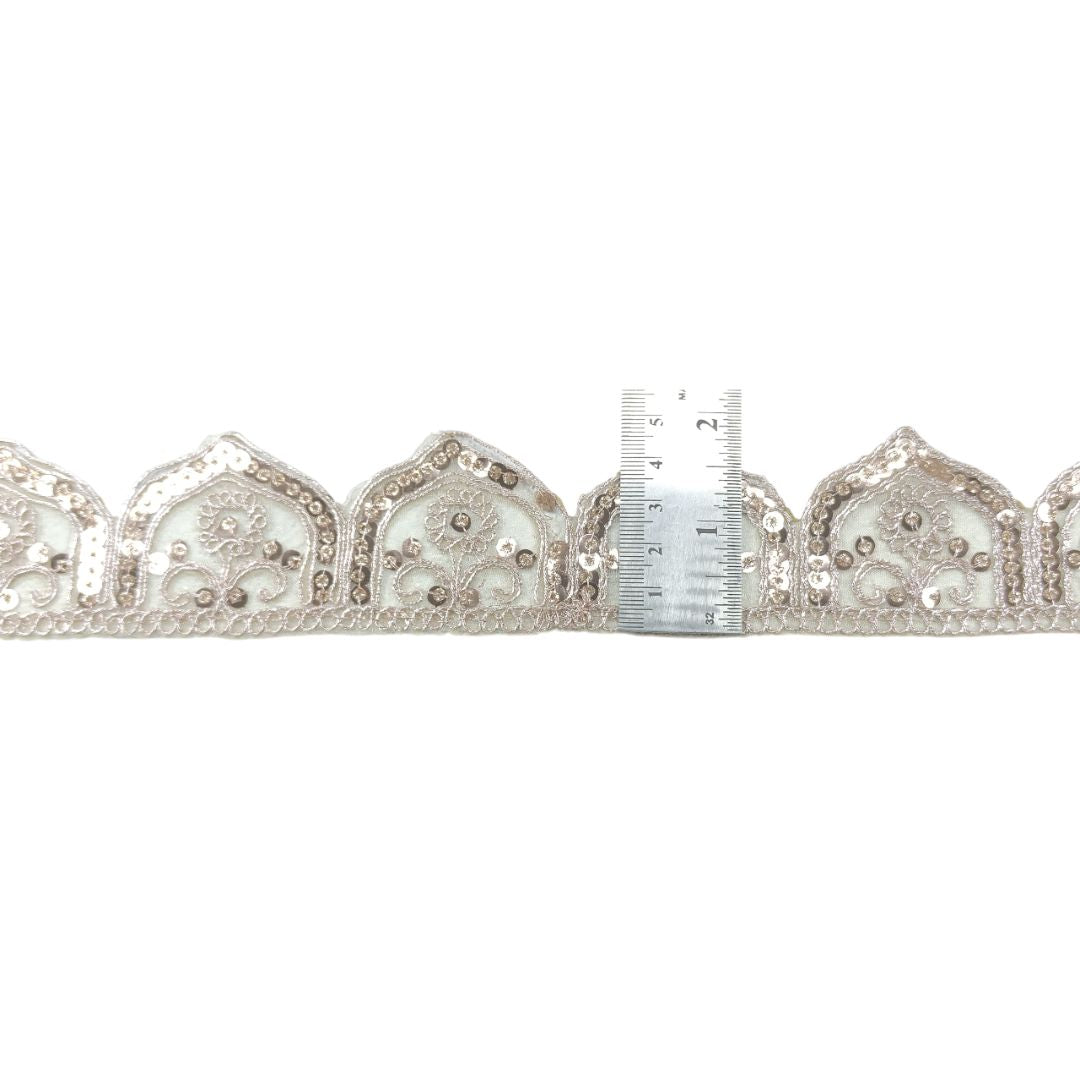 Decorative ribbon with beads and a ruler for scale on a white background