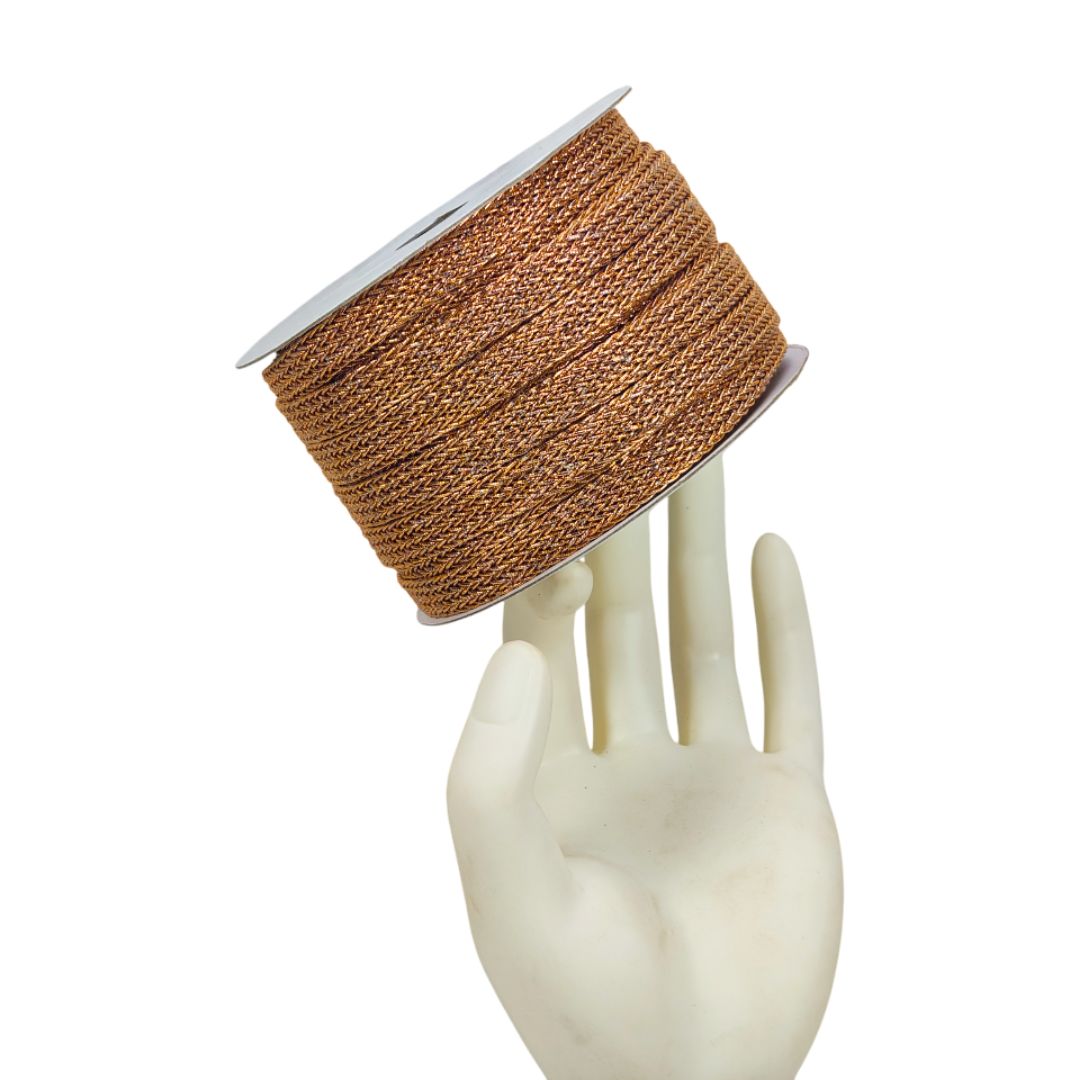 Spool of brown thread on a mannequin hand against a white background