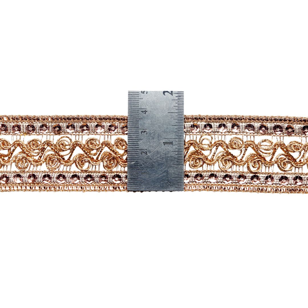 Decorative lace trim with a ruler for scale on a white background