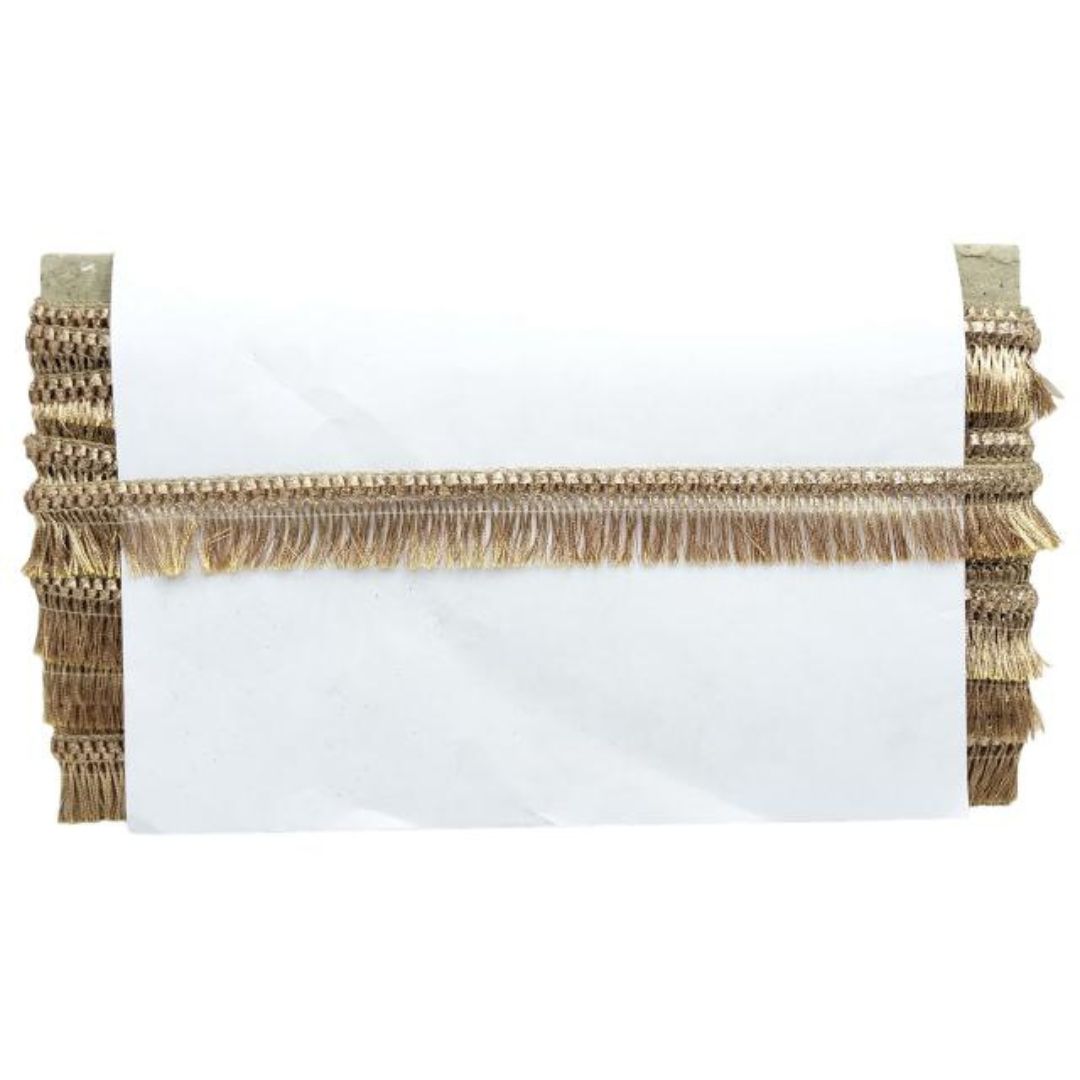 White pillow with gold fringe on a white background