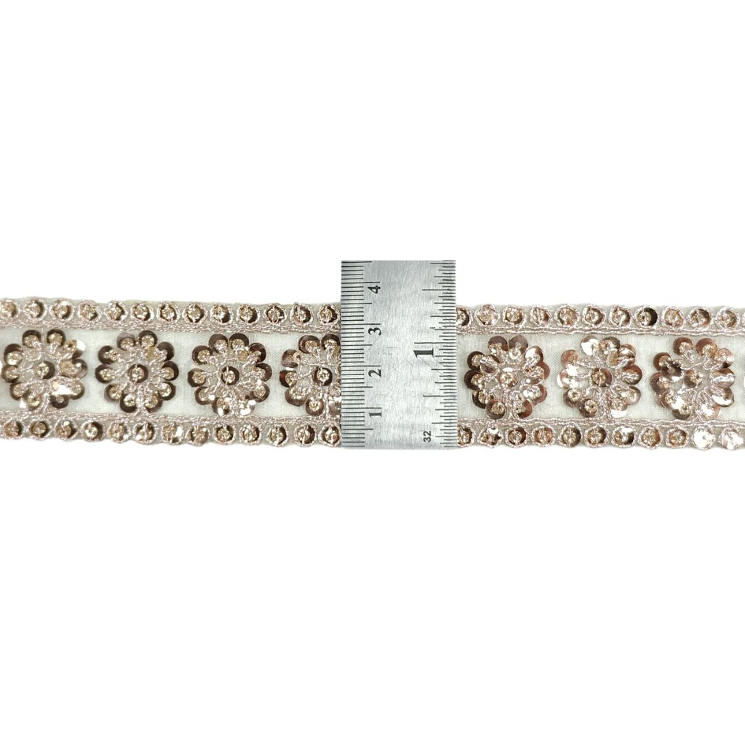 Decorative ribbon with floral patterns and a ruler for scale on a white background