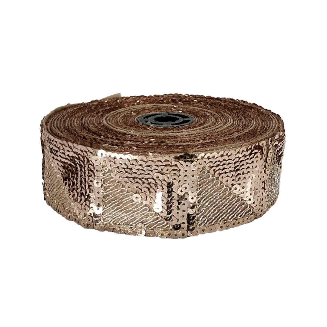Roll of rose gold sequin ribbon on a white background