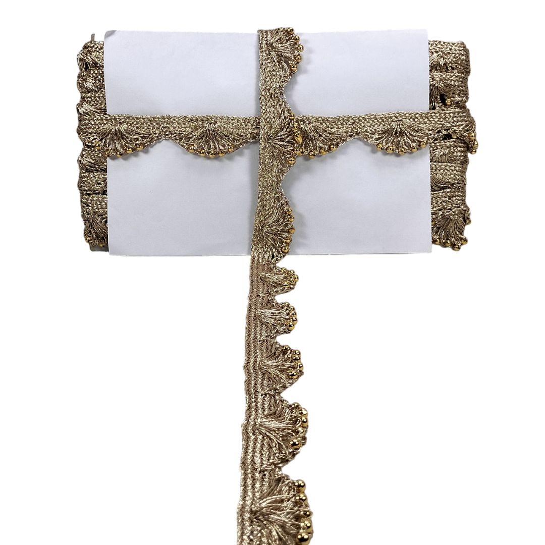 Decorative table runner with gold fringe on a white background