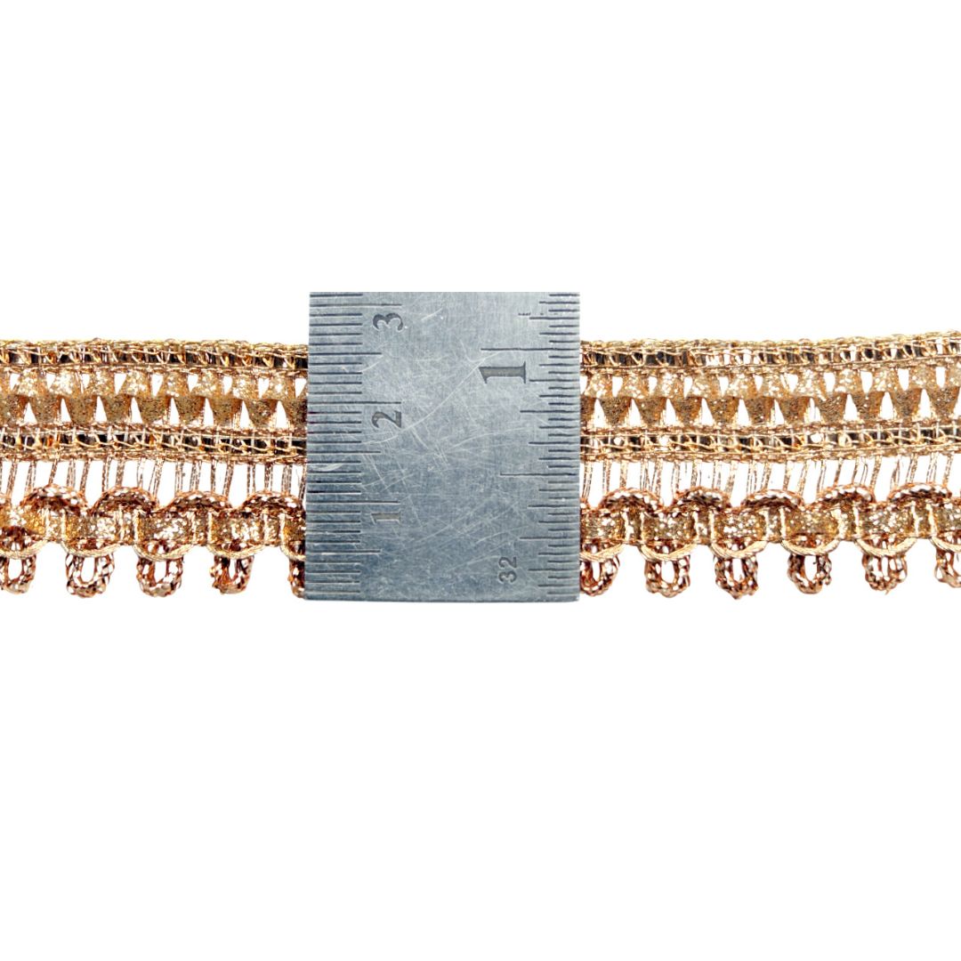 Gold lace trim with a ruler for measurement on a white background
