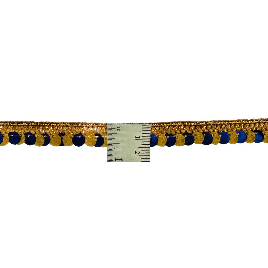 Gold and blue pom-pom trim with a ruler for scale on a white background