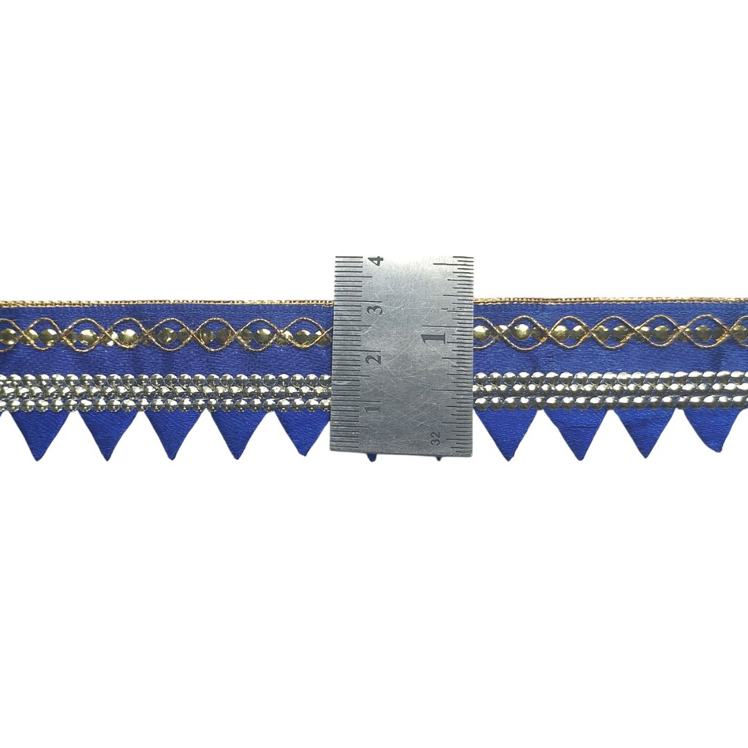 Blue decorative ribbon with gold patterns and a metal ruler for measurement on a white background