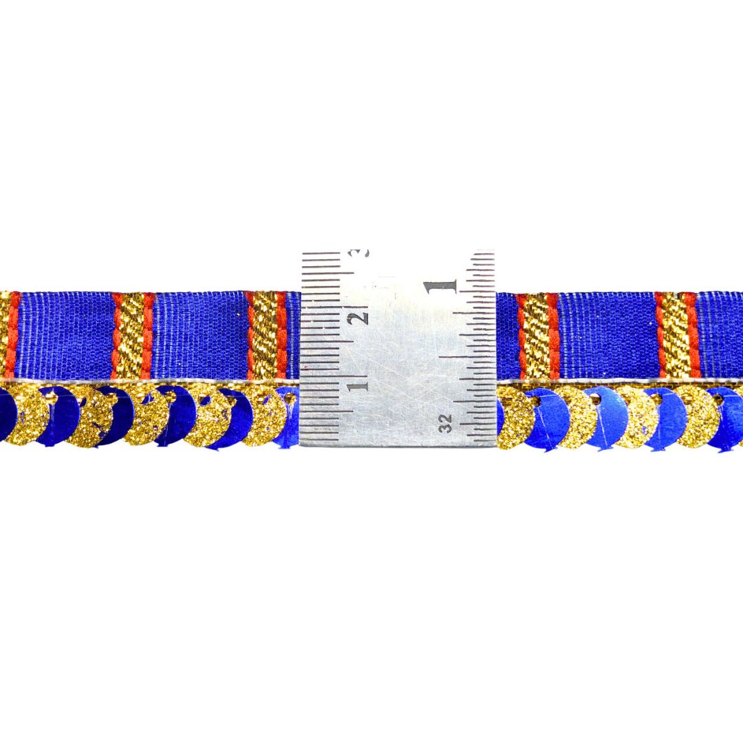 Ribbon with gold and blue design and a ruler for scale on a white background