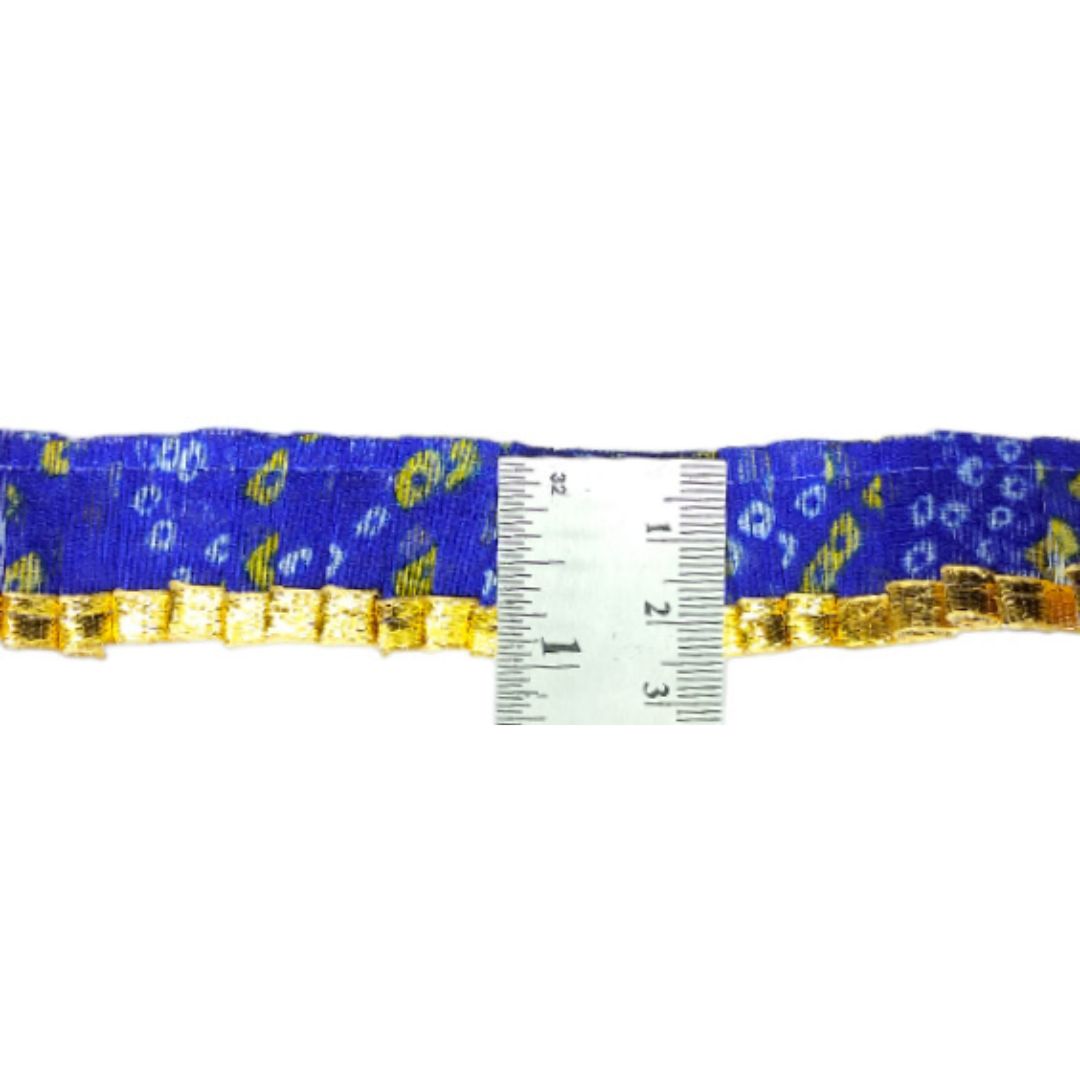 Blue ribbon with gold accents and a ruler for scale on a white background