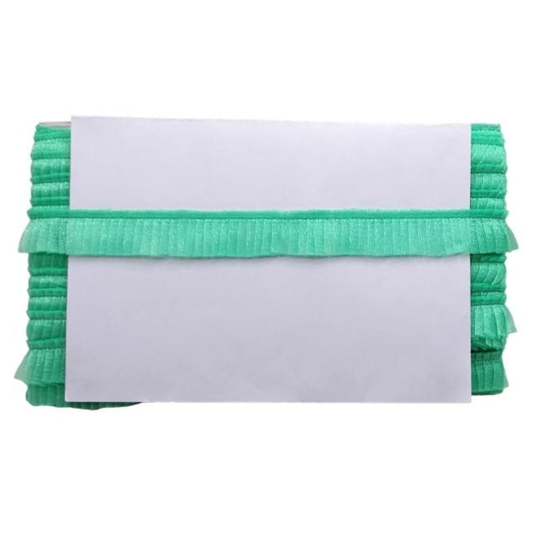 Stack of green ruffled fabric with a white label on a white background