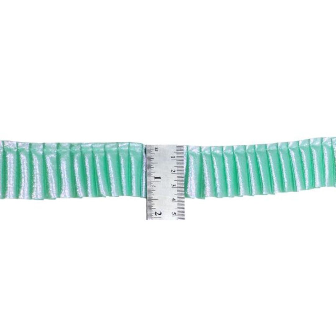 Green ruffled trim with a ruler for scale on a white background