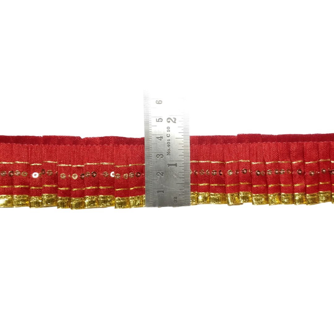 Red ribbon with gold trim and a ruler for measurement on a white background