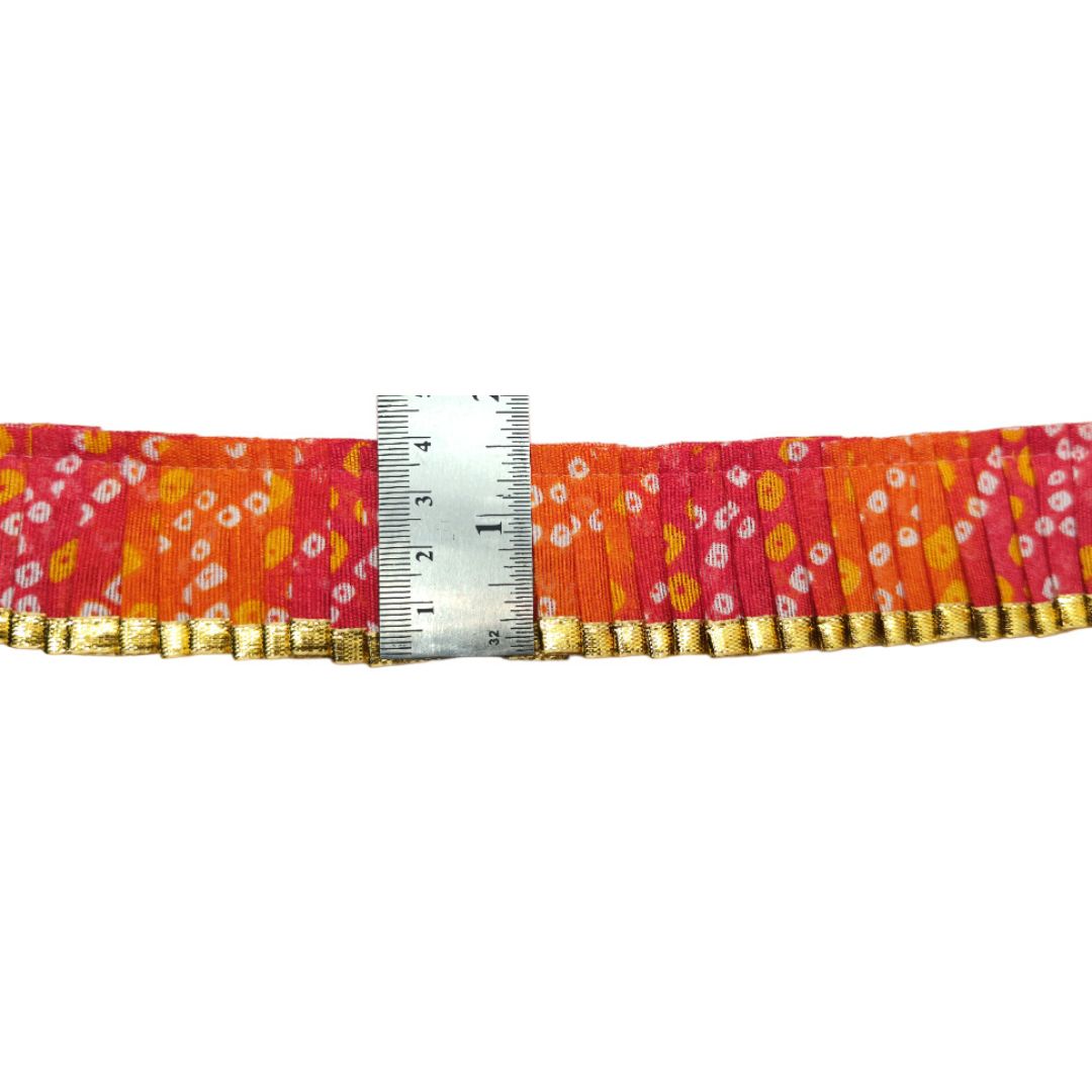 Fabric strip with floral pattern and gold trim, measured against a ruler on a white background