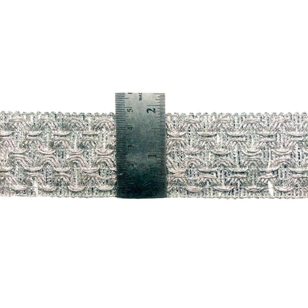 Decorative lace trim with a ruler for scale on a white background