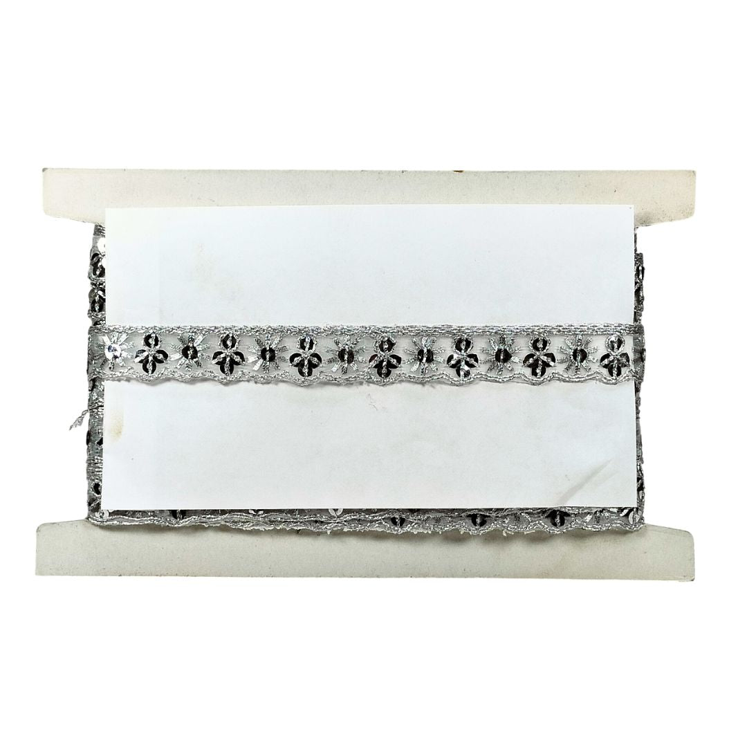 White fabric roll with black lace trim on a white background
