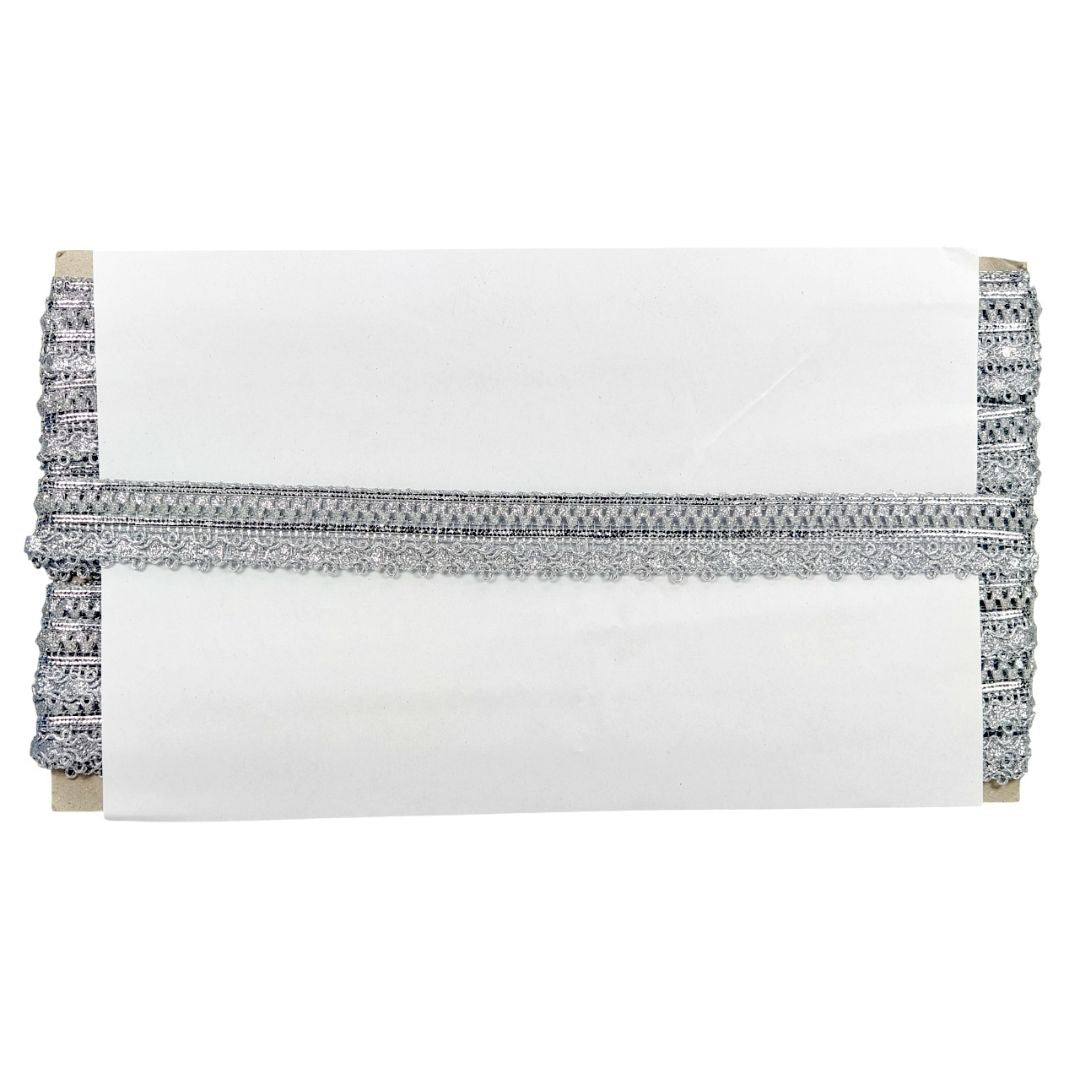 White clutch with decorative black and silver trim on a white background