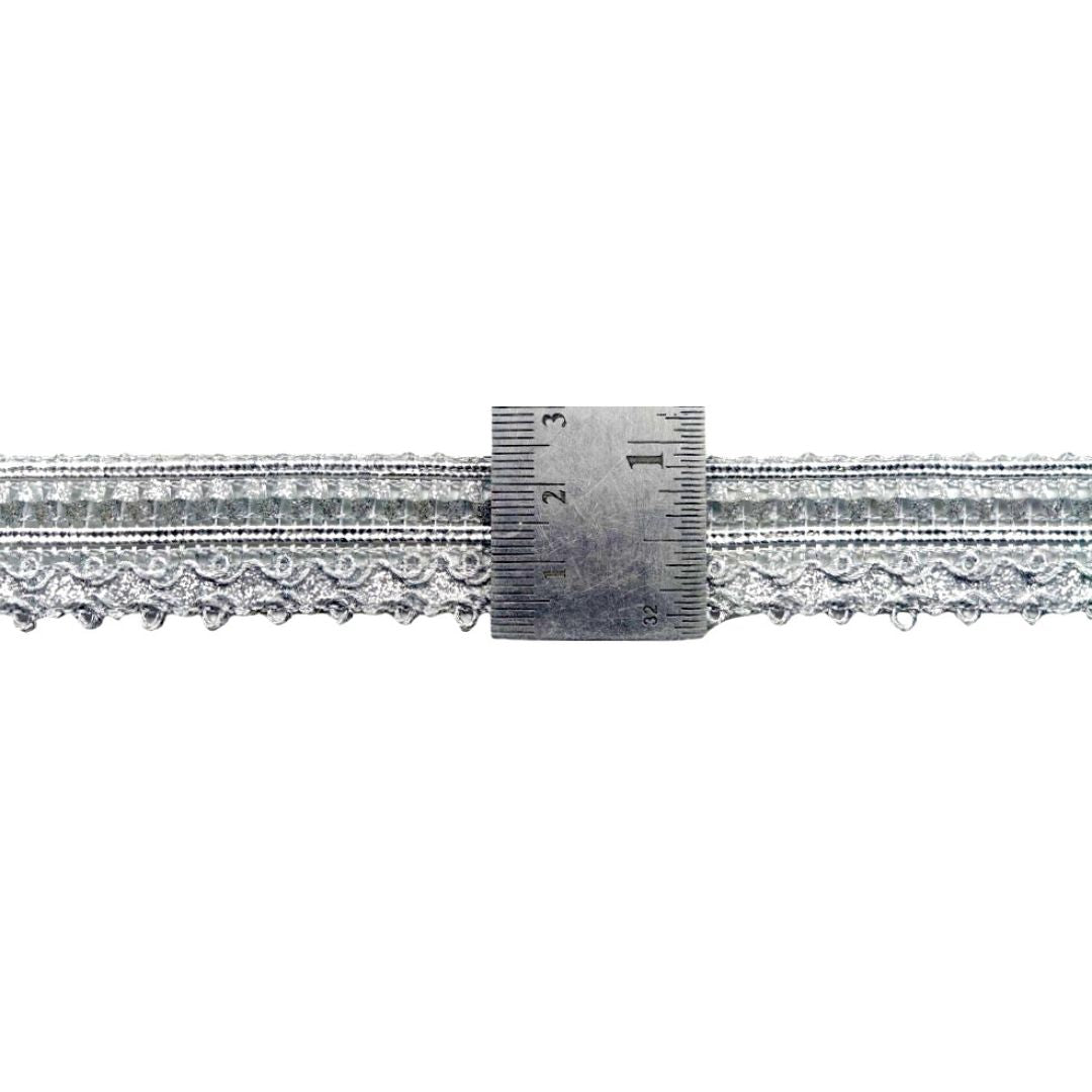 Metallic lace trim with a ruler for measurement on a white background