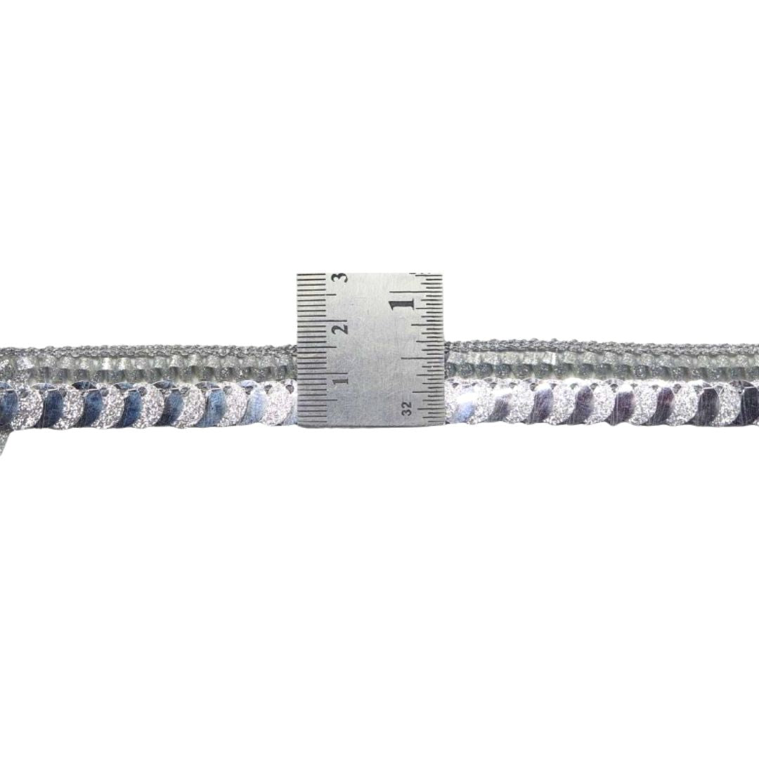 Close-up of a braided rope with a ruler for scale on a white background