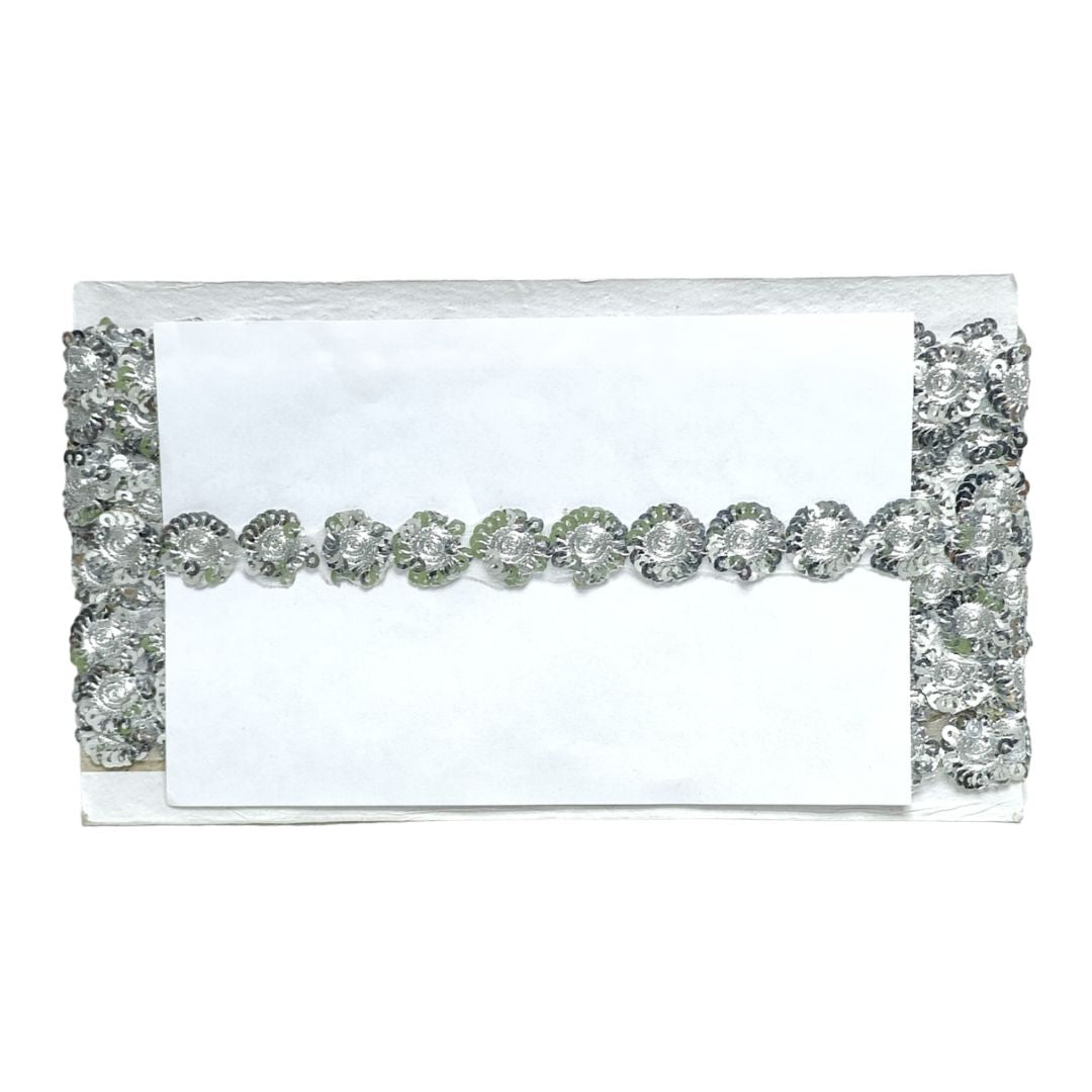 White clutch bag with silver embellishments on a white background