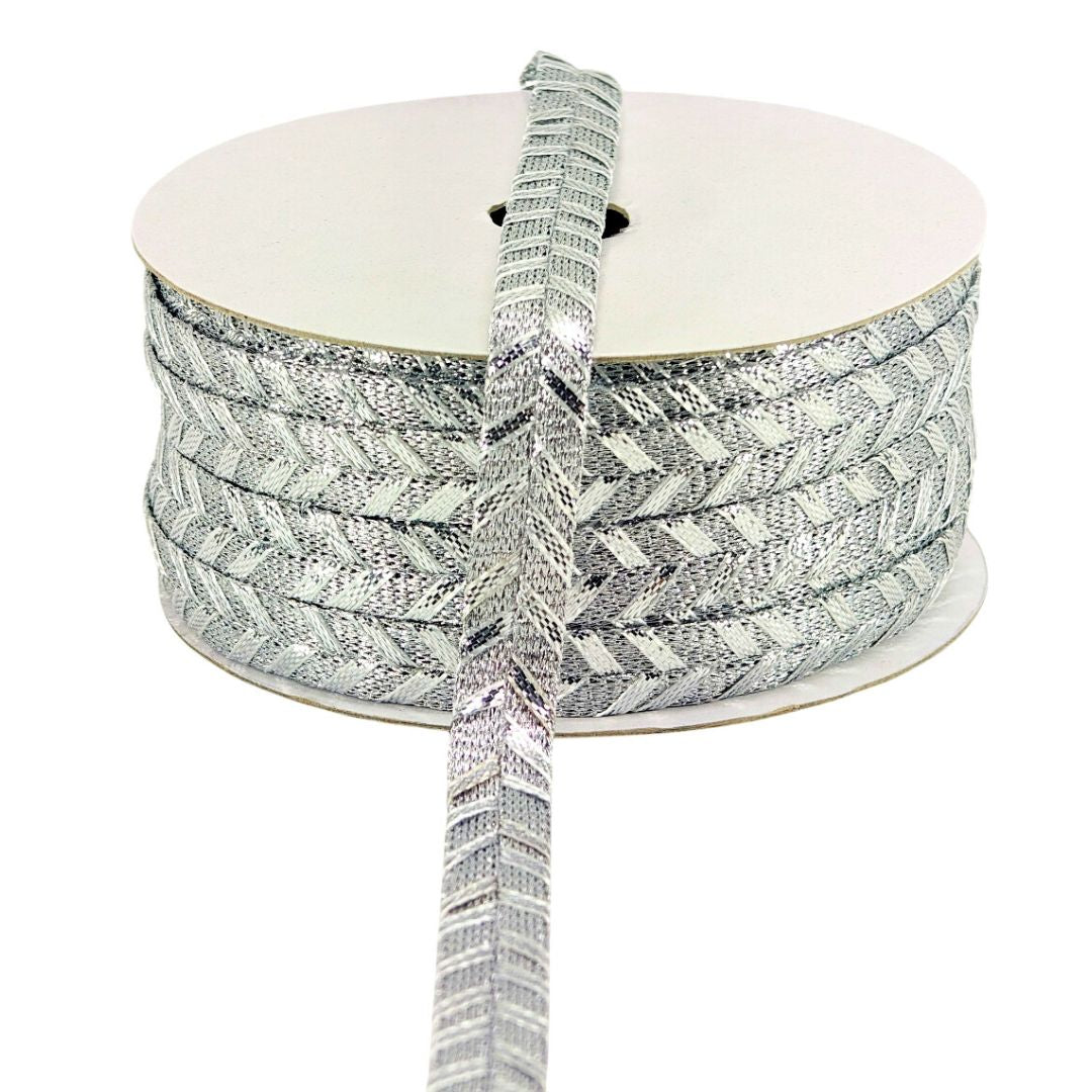 Spool of silver and white patterned ribbon on a white background