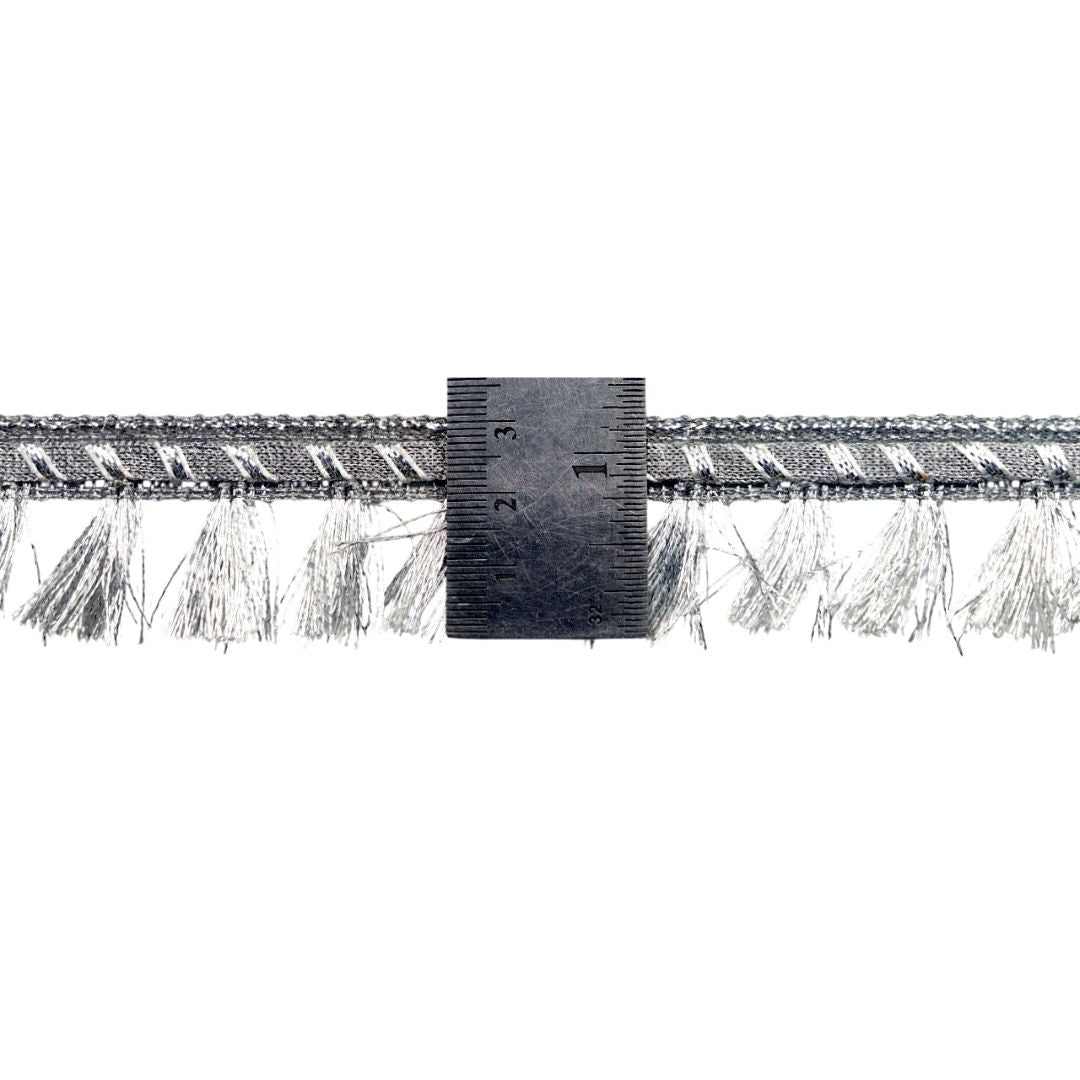 Metallic fringe trim with a ruler for scale on a white background