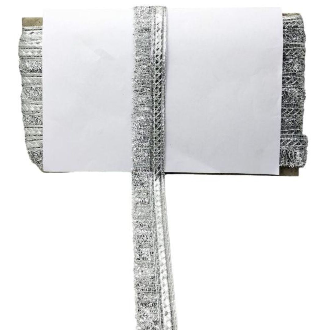 Roll of reflective tape with silver and black pattern on a white background