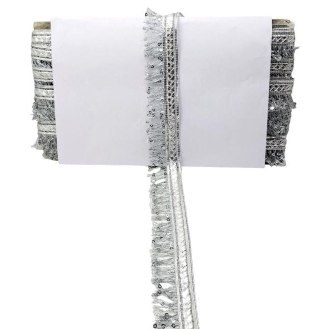 White clutch with silver fringe and sequin details on a white background