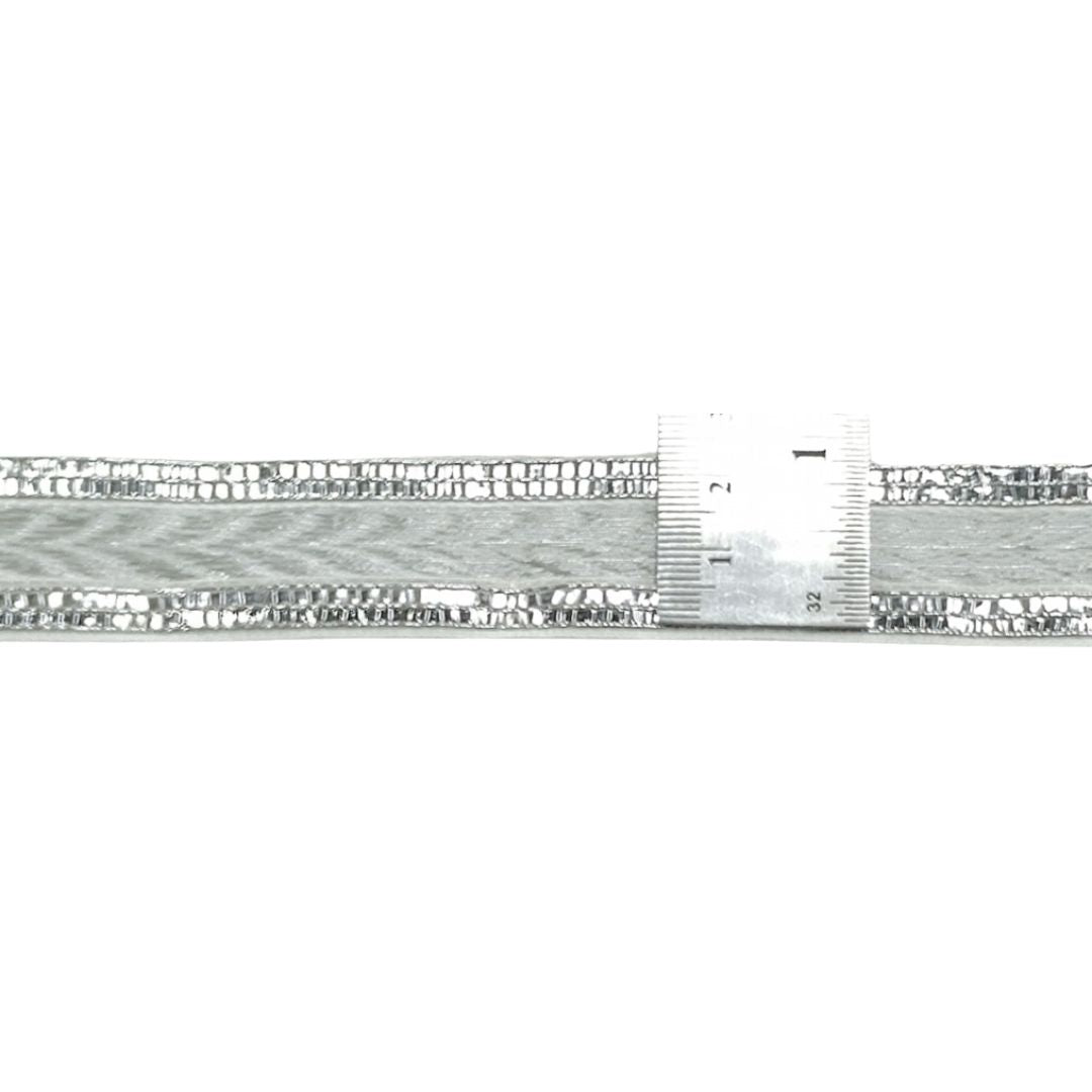 Metallic bracelet with a ruler for scale on a white background