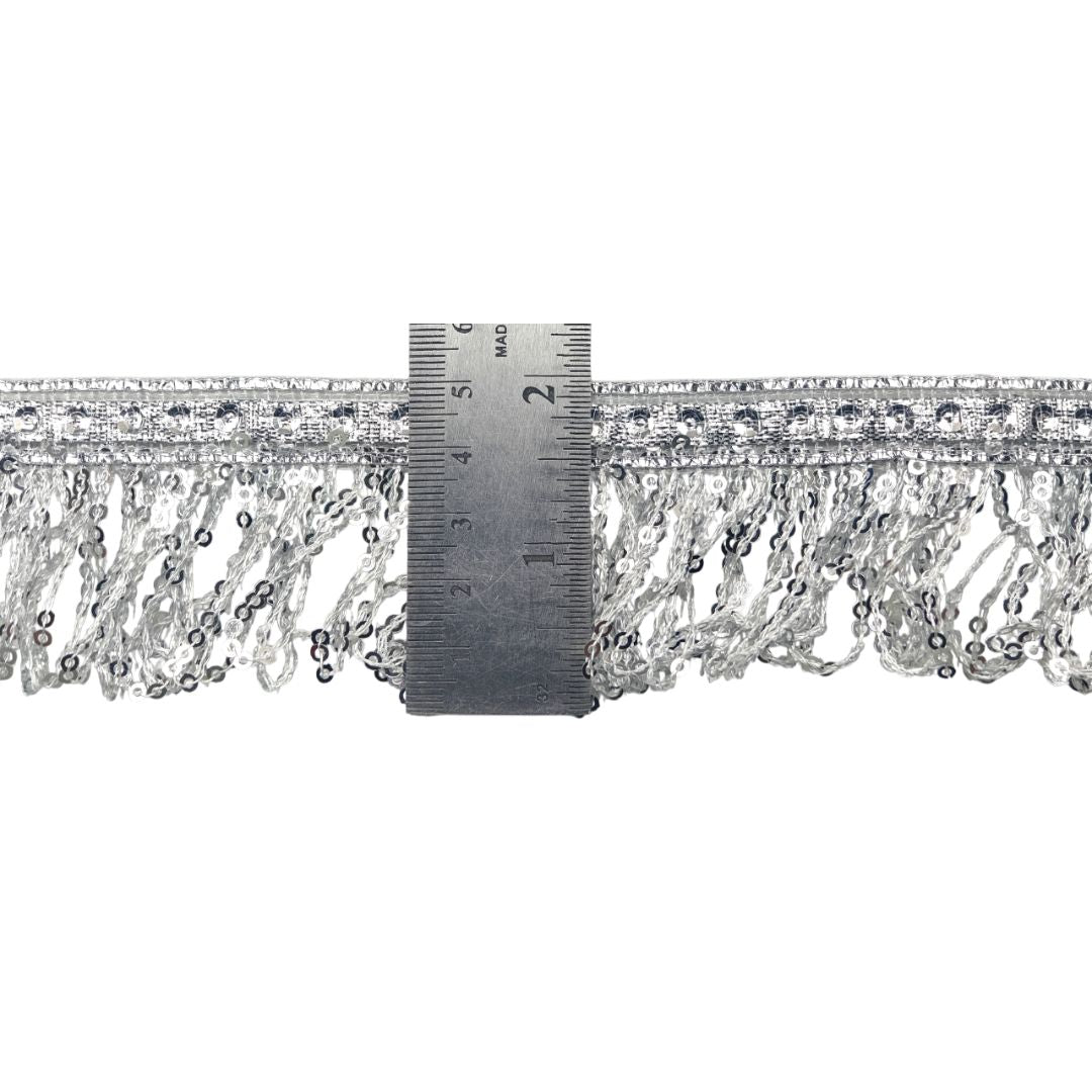 Silver fringe trim with a ruler for scale on a white background