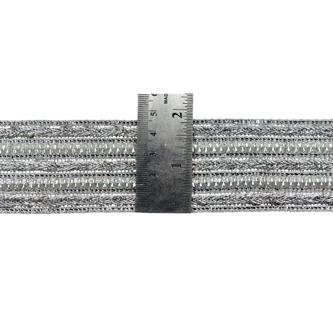 Metallic braided cable with a ruler for scale on a white background