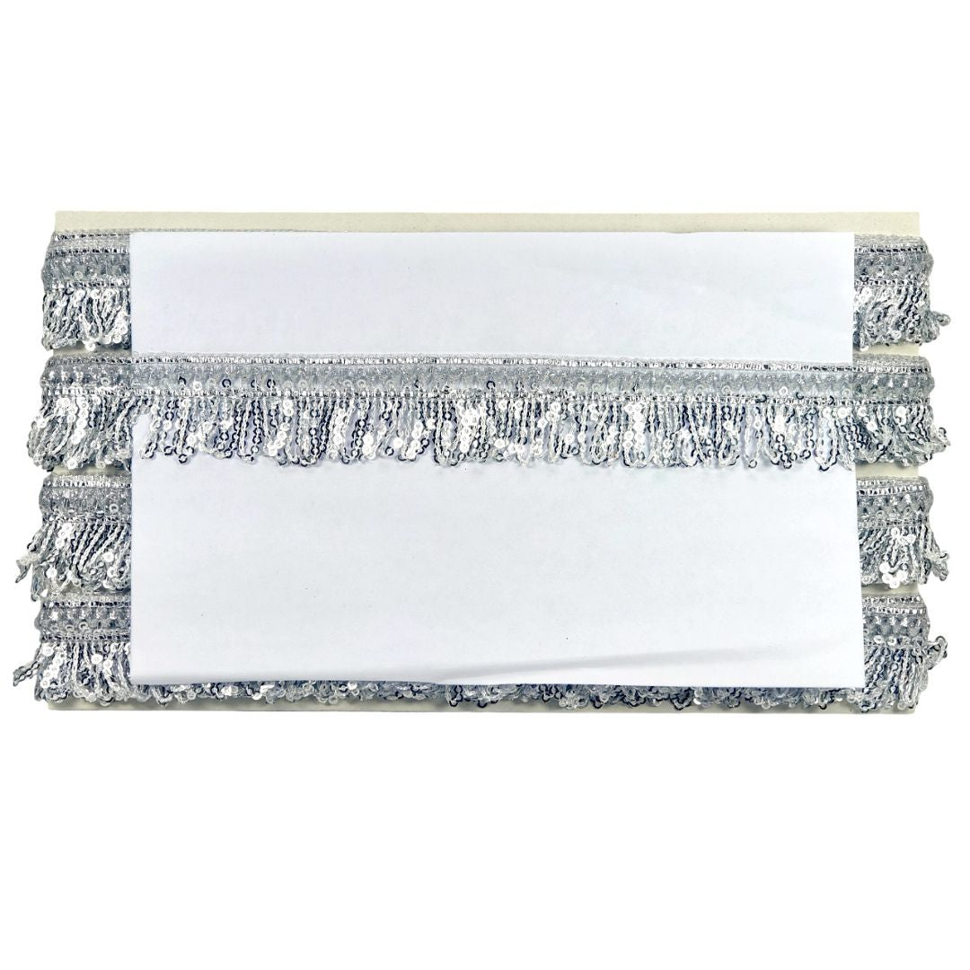 Stack of white napkins with silver fringe on a white background