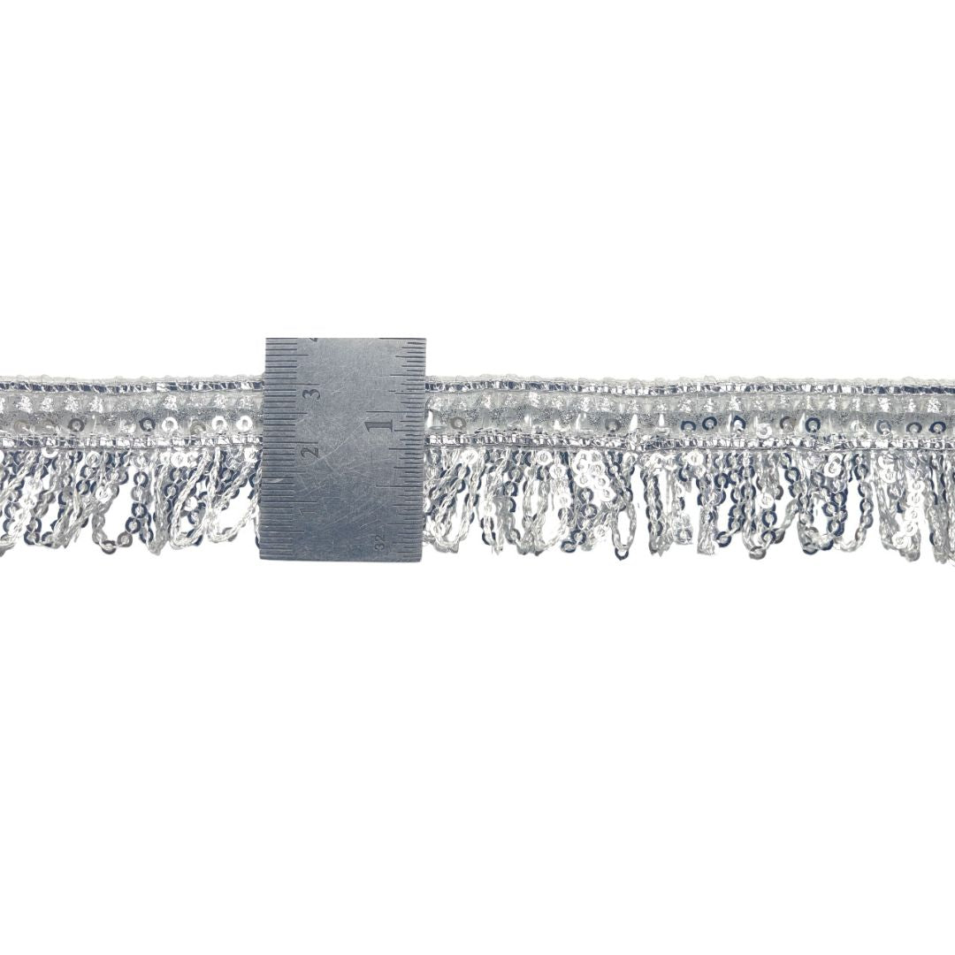 Silver fringe trim with a ruler for scale on a white background