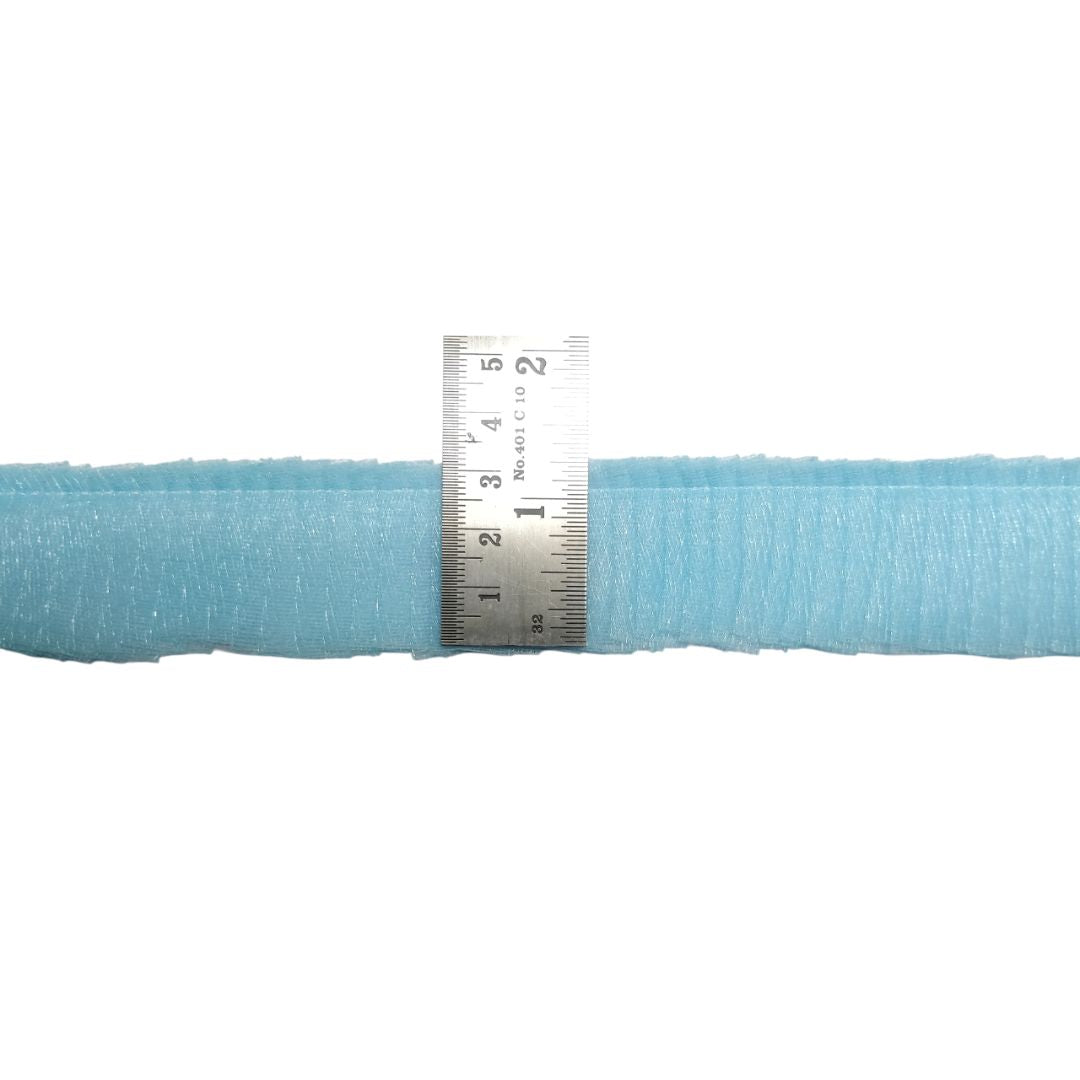 Roll of light blue fabric with a ruler for scale on a white background