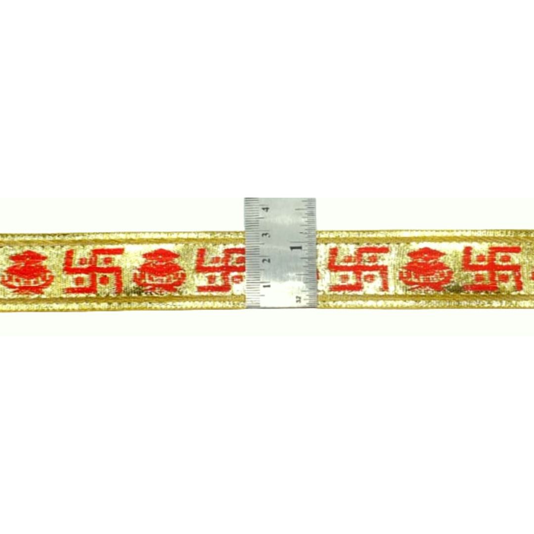 Textile strip with red and gold text and a ruler for scale on a white background