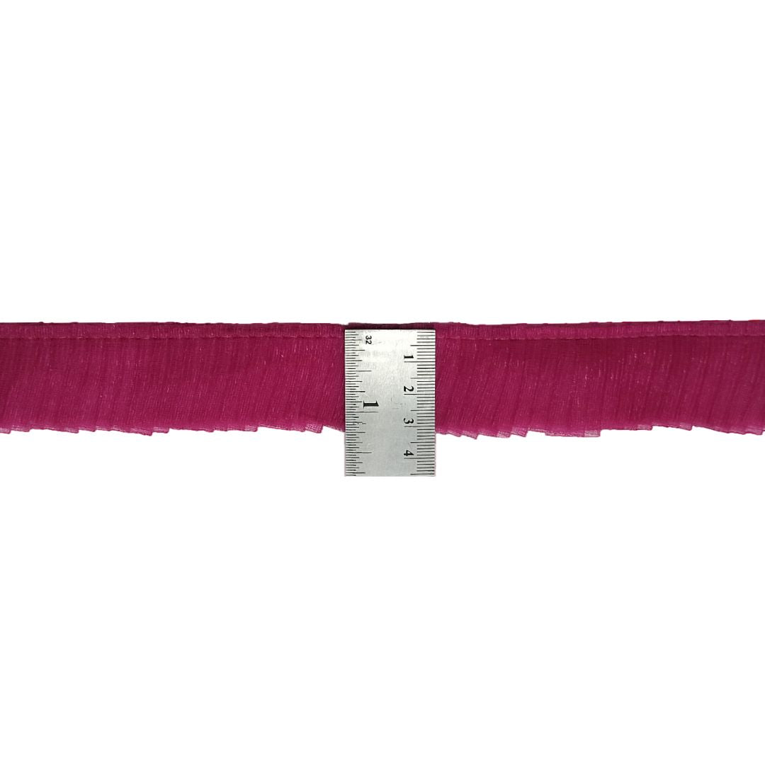 Fuchsia fringe trim with a ruler for measurement on a white background