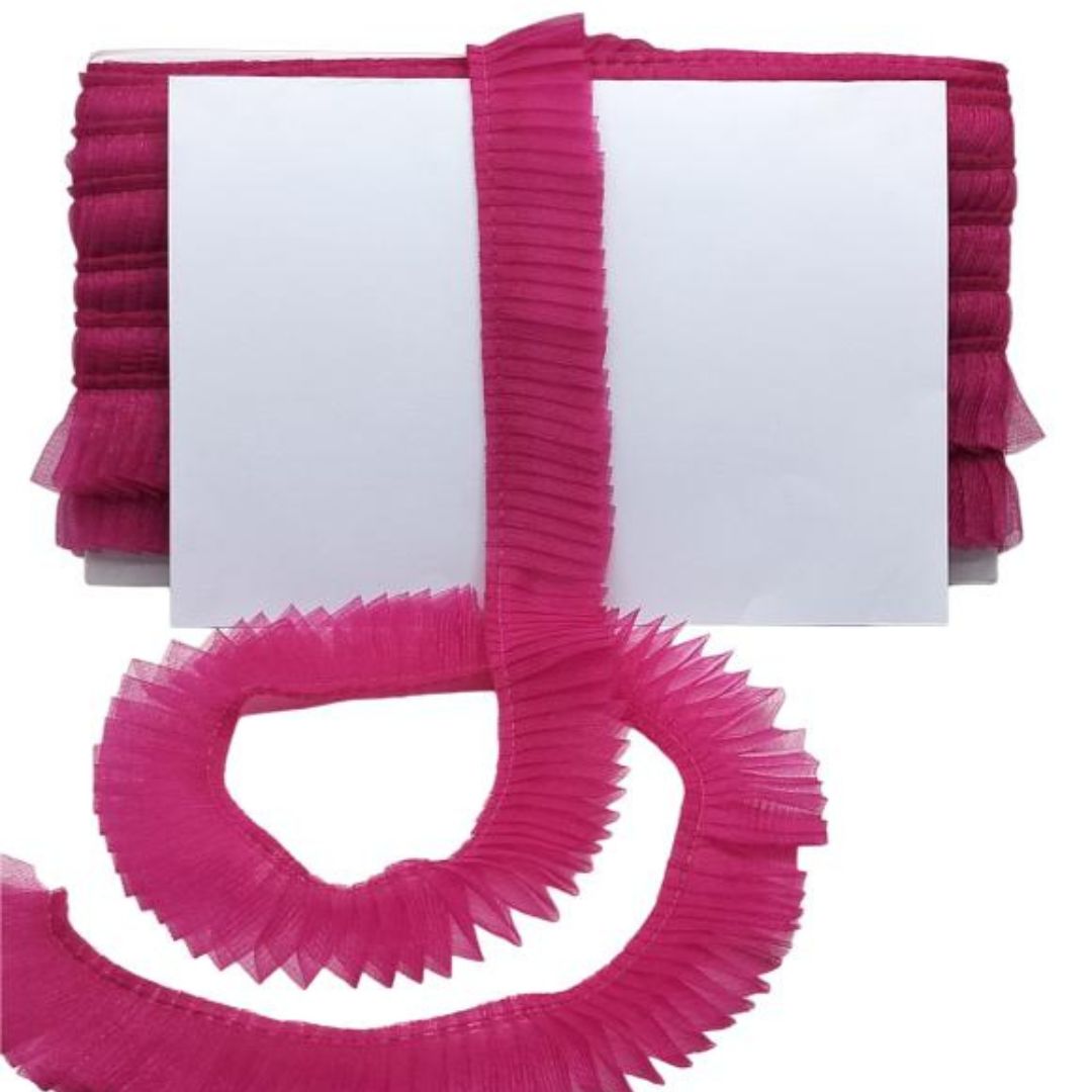 Pink pleated ribbon with a white card on a white background