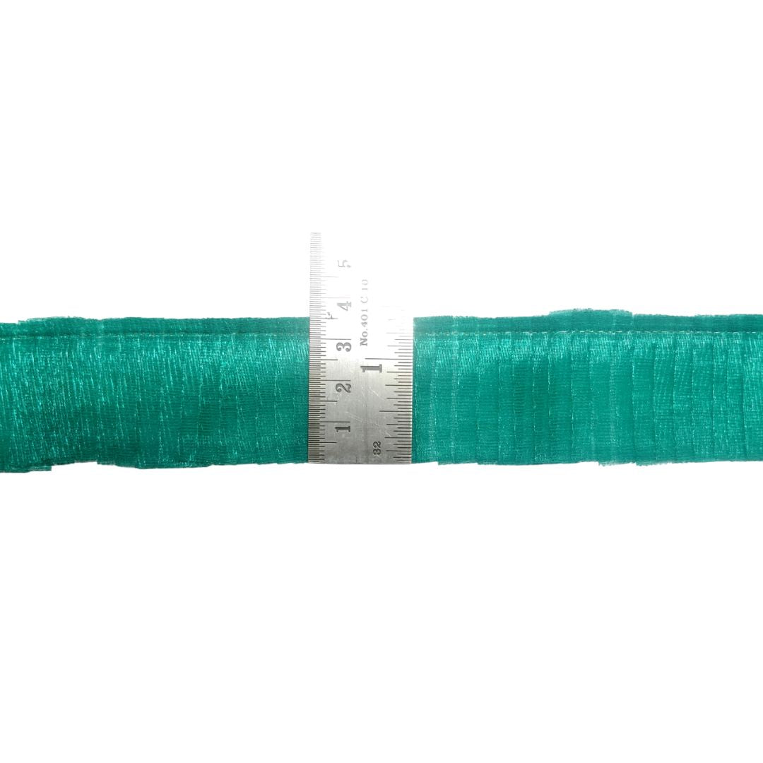 Teal yarn roll with a ruler for scale on a white background