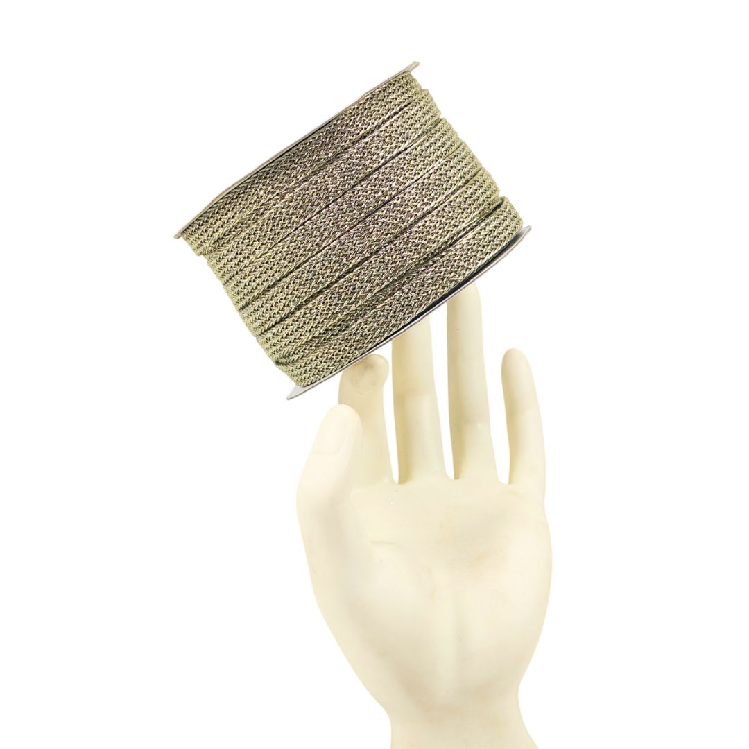 Spool of beige ribbon on a mannequin hand against a white background