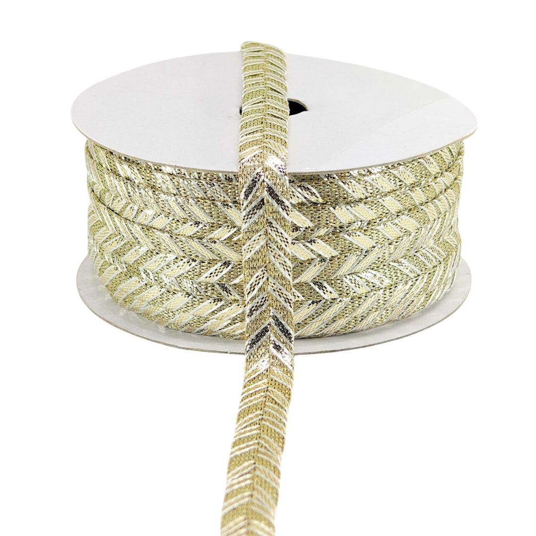 Spool of gold and silver patterned ribbon on a white background