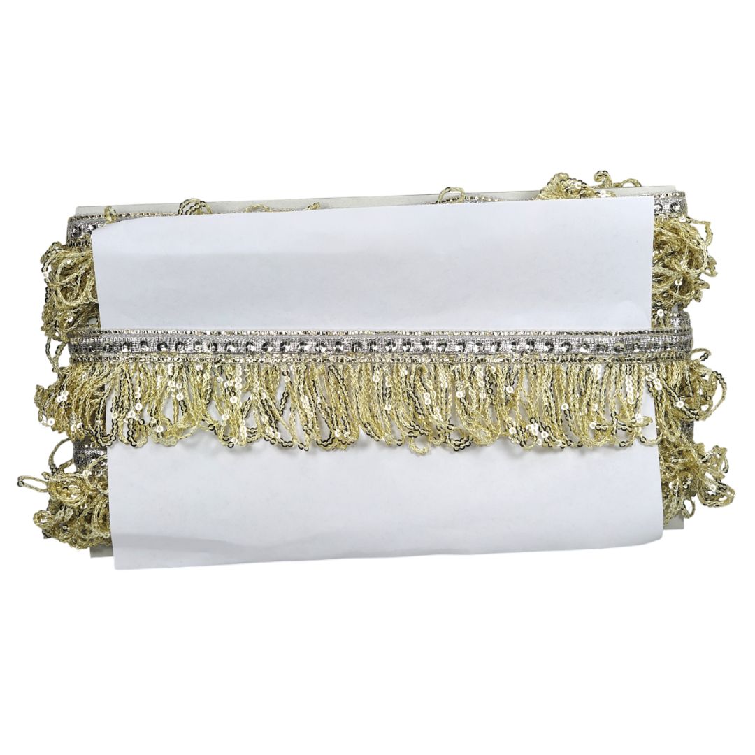 White clutch with gold fringe and embellishments on a white background