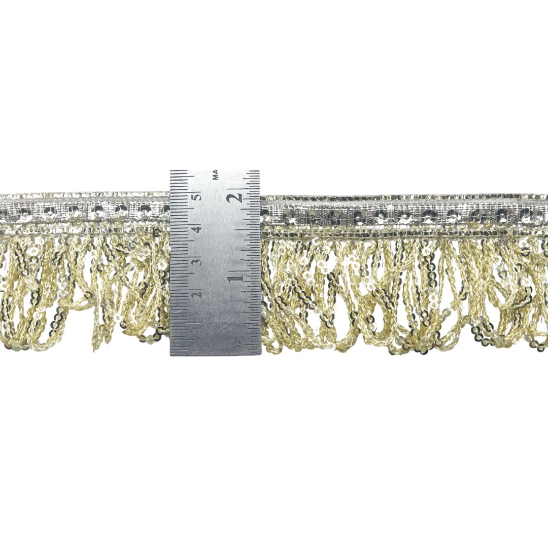 Gold fringe trim with a ruler for scale on a white background