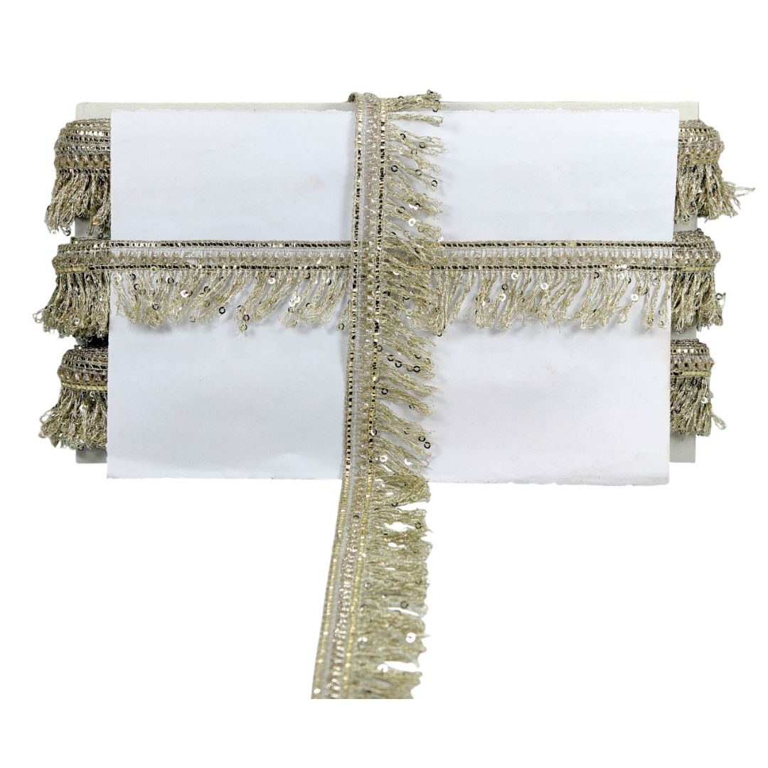 White napkin with gold fringe and sequin trim on a white background