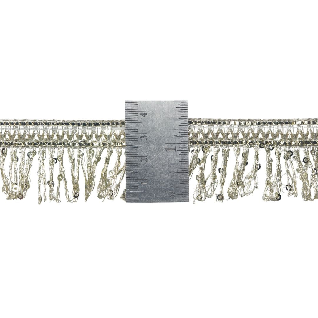 Decorative trim with beads and a ruler for scale on a white background