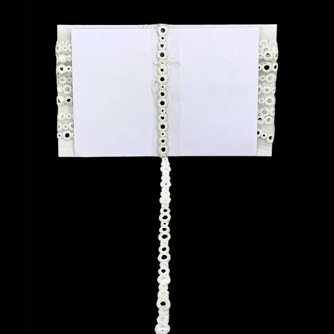 White fabric with decorative lace trim on a black background