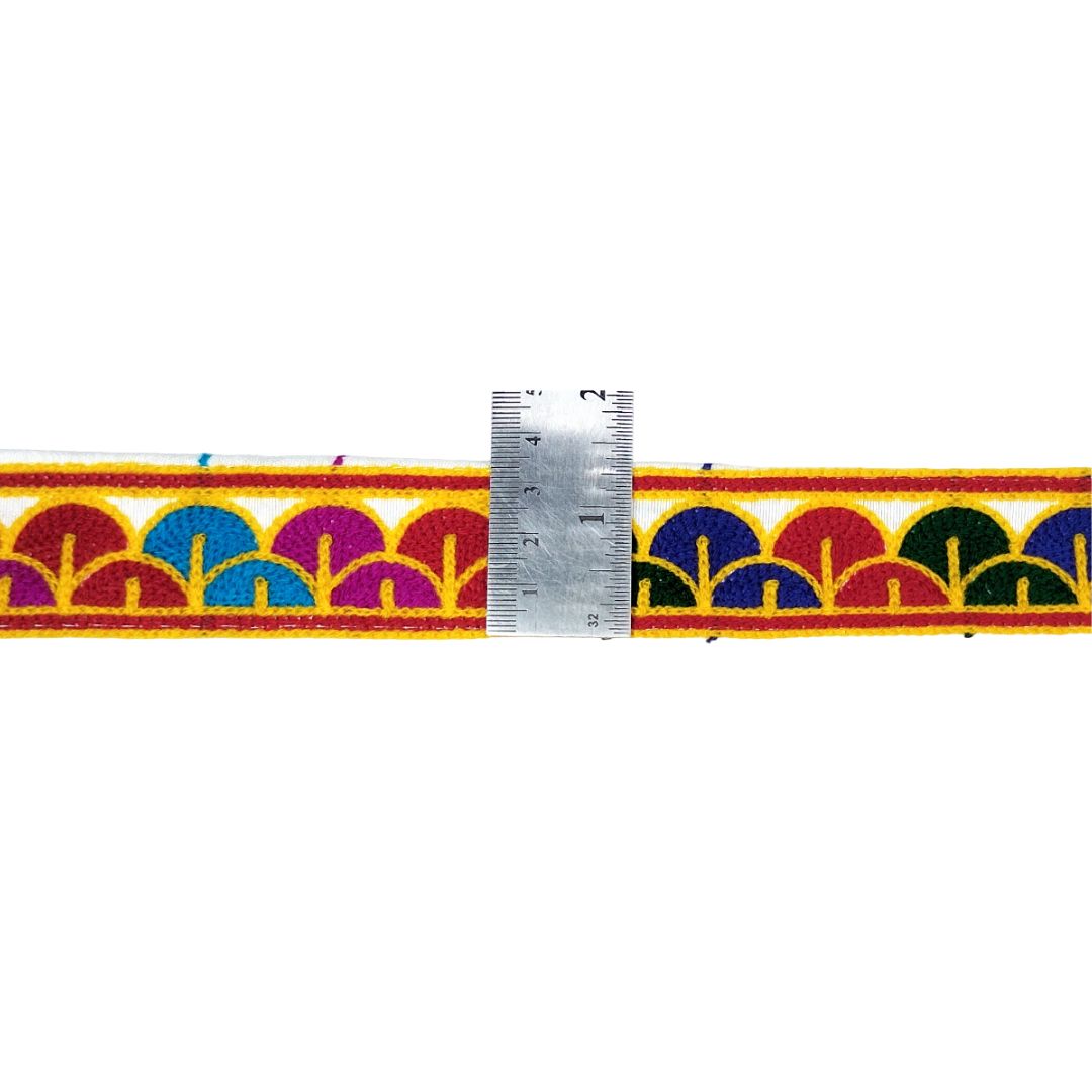 Colorful patterned belt with a ruler for scale on a white background