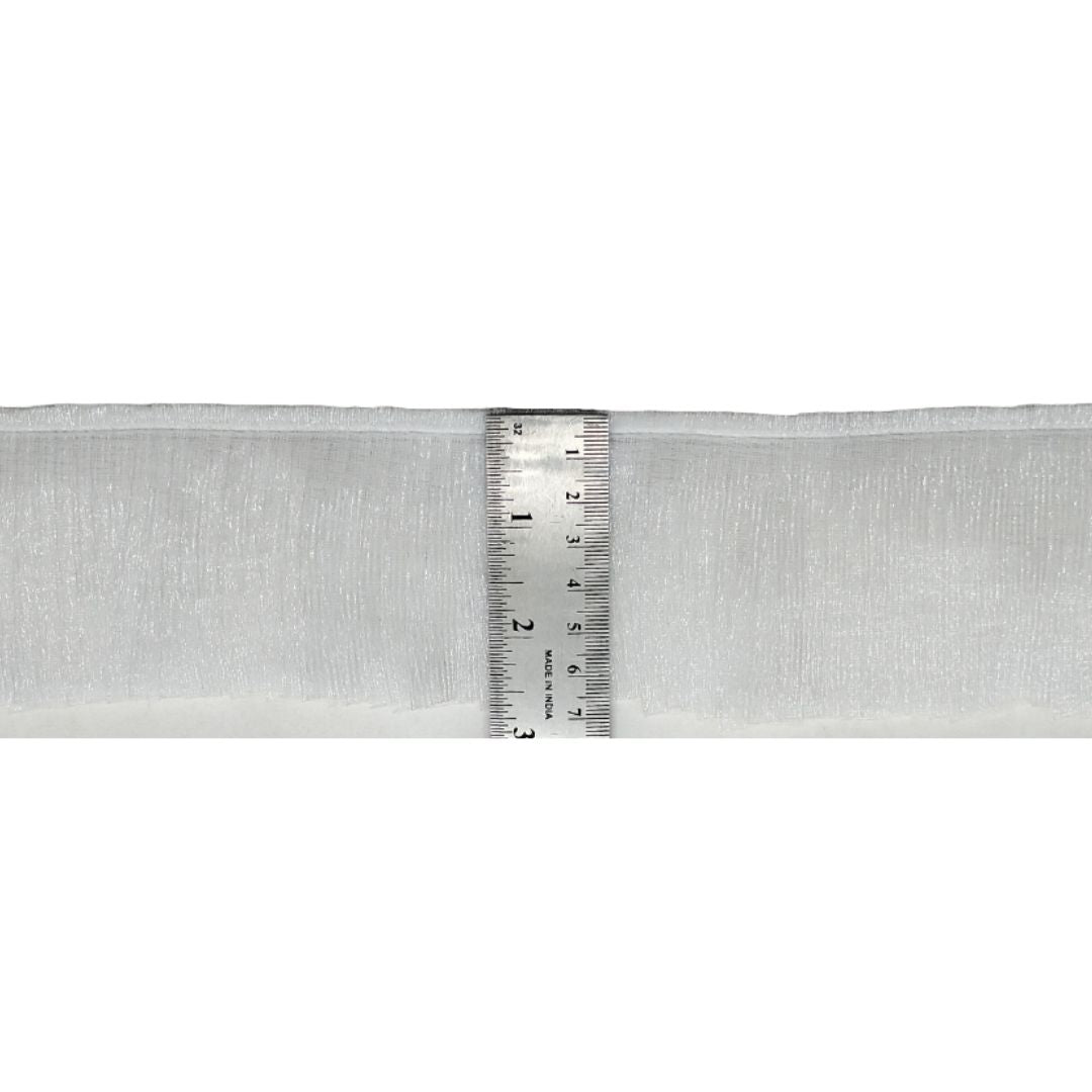 Strip of white mesh fabric with a ruler for scale on a white background
