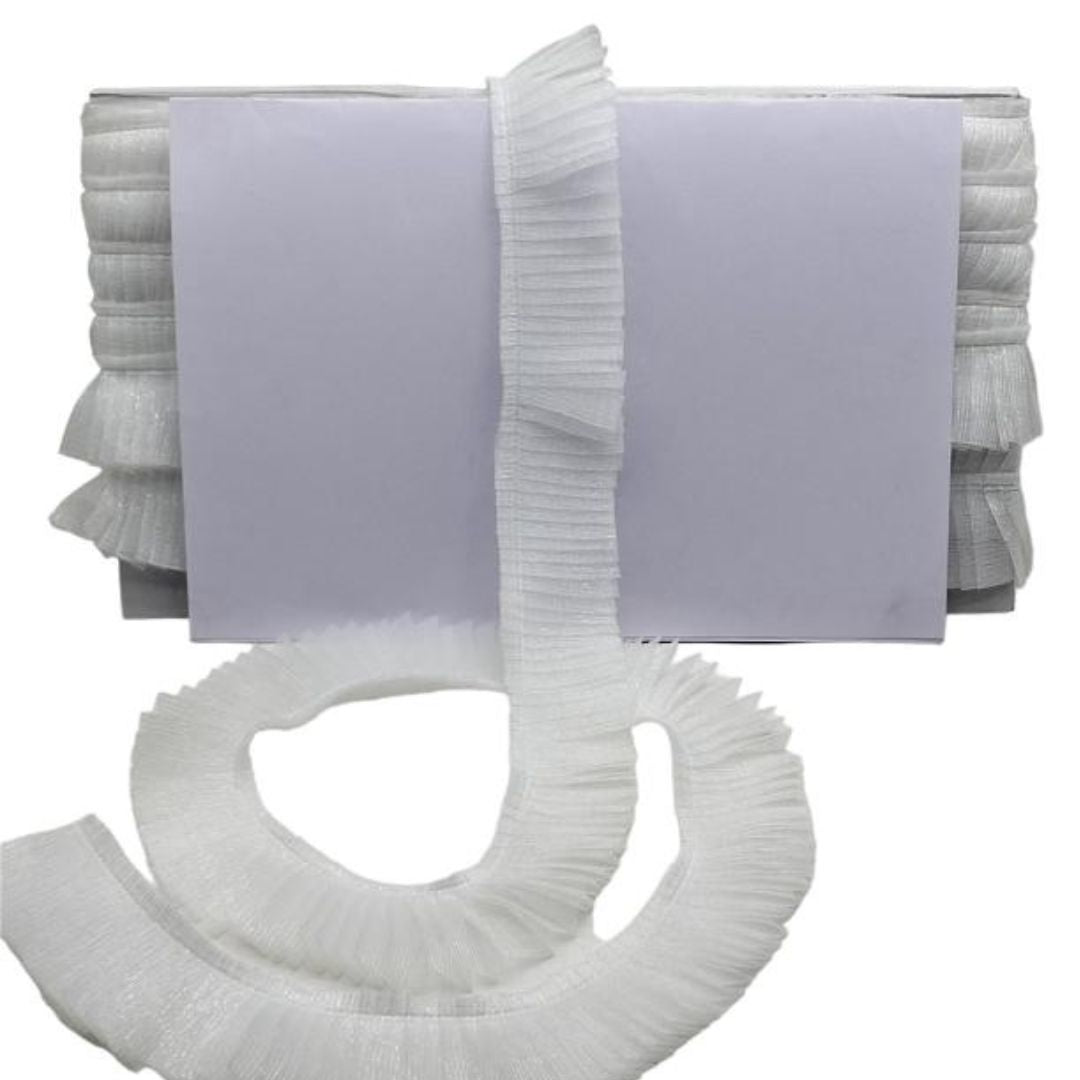 White pleated headband with ruffled ends on a white background