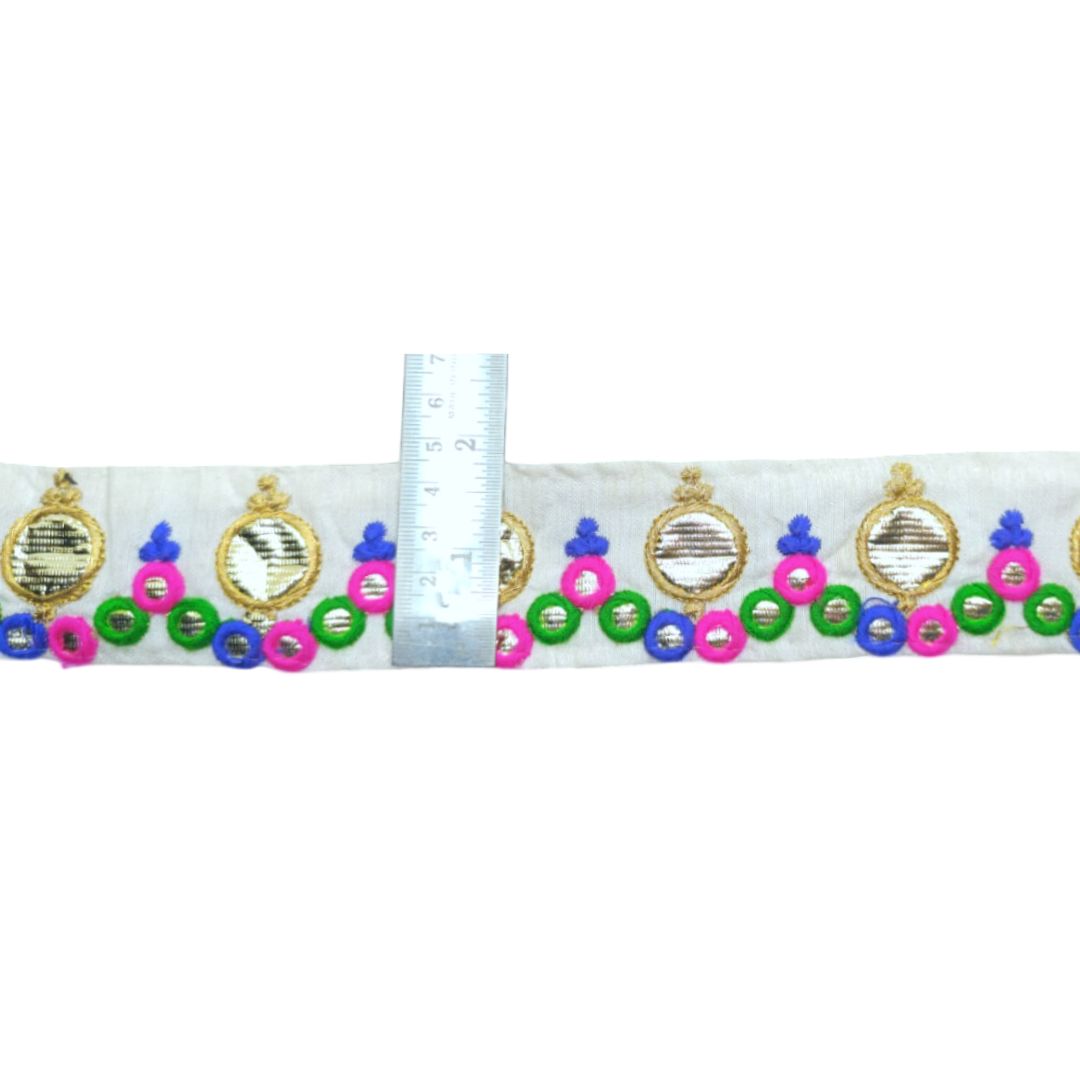 Decorative ribbon with colorful pendants and a ruler for scale on a white background