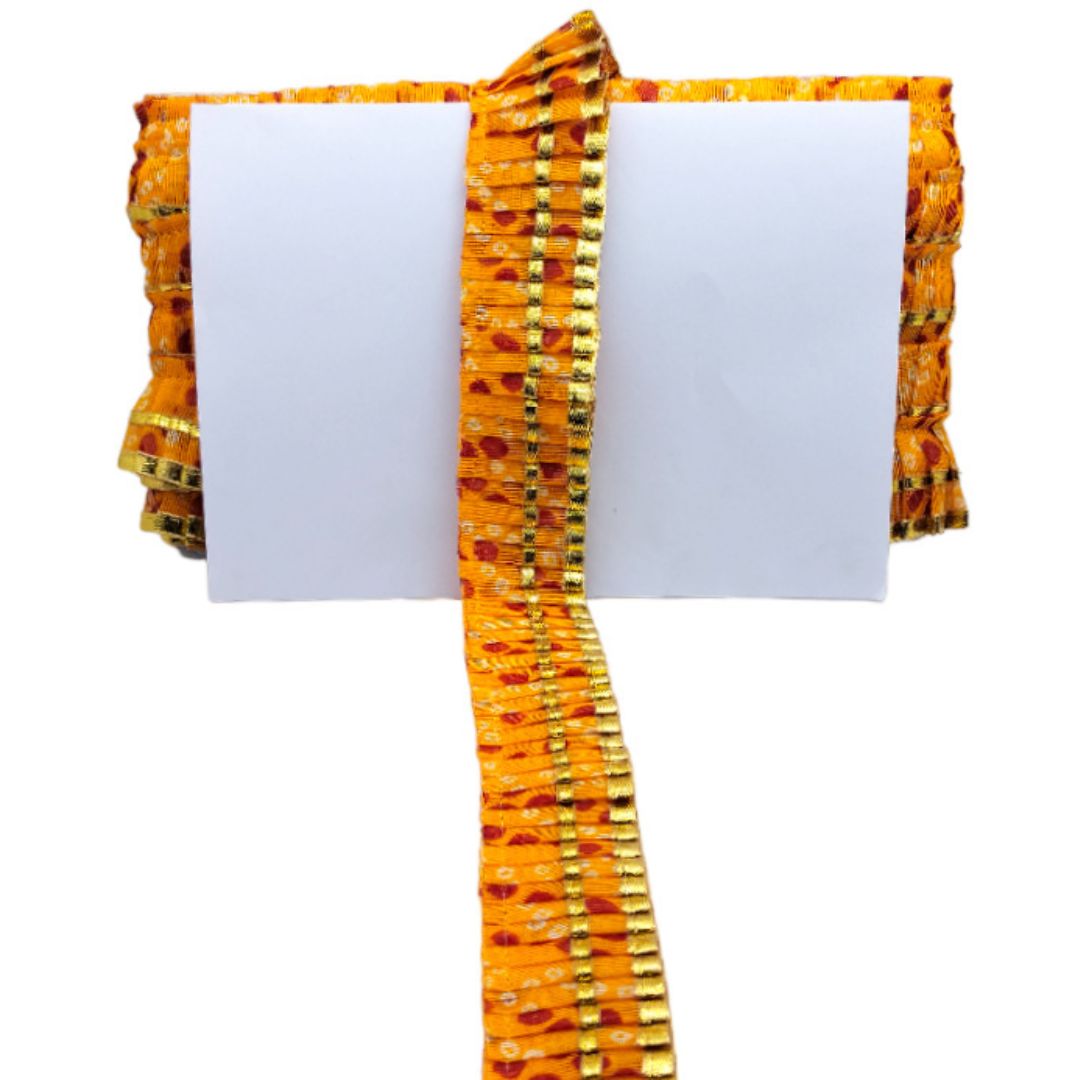 Decorative yellow and orange fabric with a white card on a white background